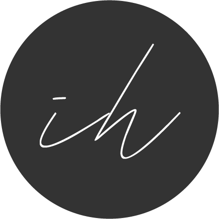 White cursive text 'ih' on a black circular background.
