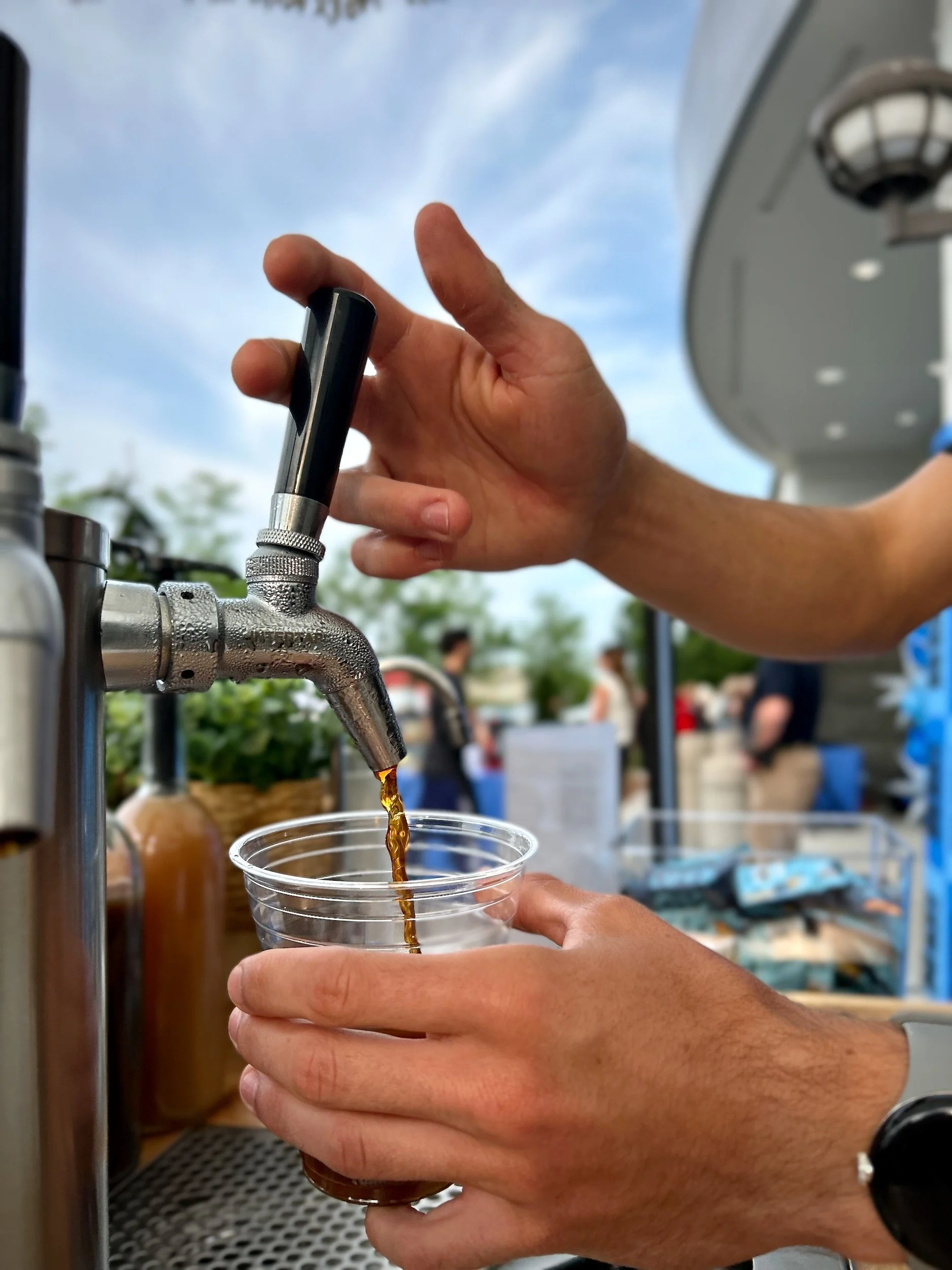 Barista pouring a cold beverage from The Coffee Cart's tap system during the Nordstrom Rack grand opening in Knoxville.