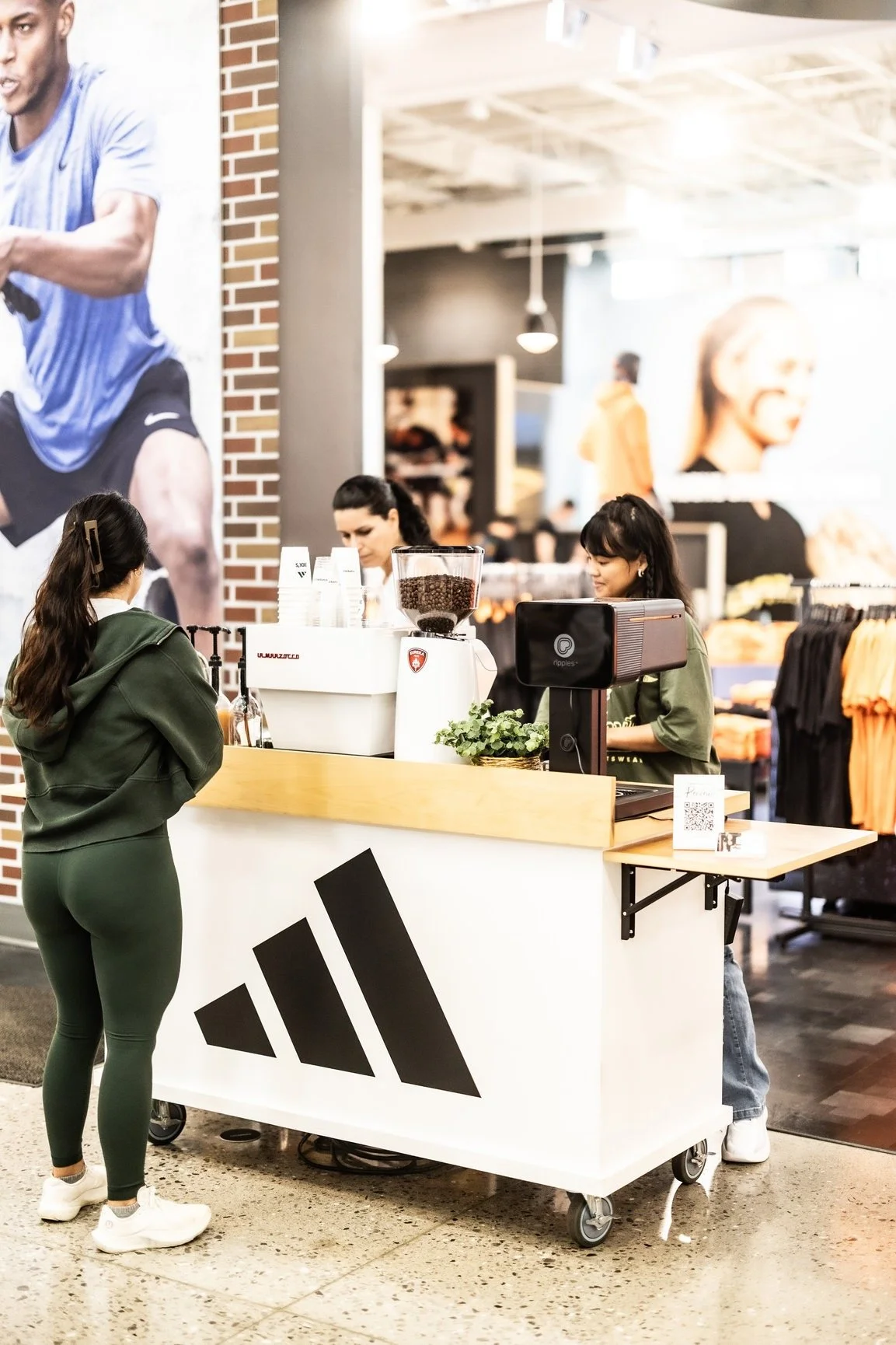 Customer ordering at The Coffee Cart's Adidas-branded coffee cart during a brand activation at Dick's House of Sport in Knoxville.