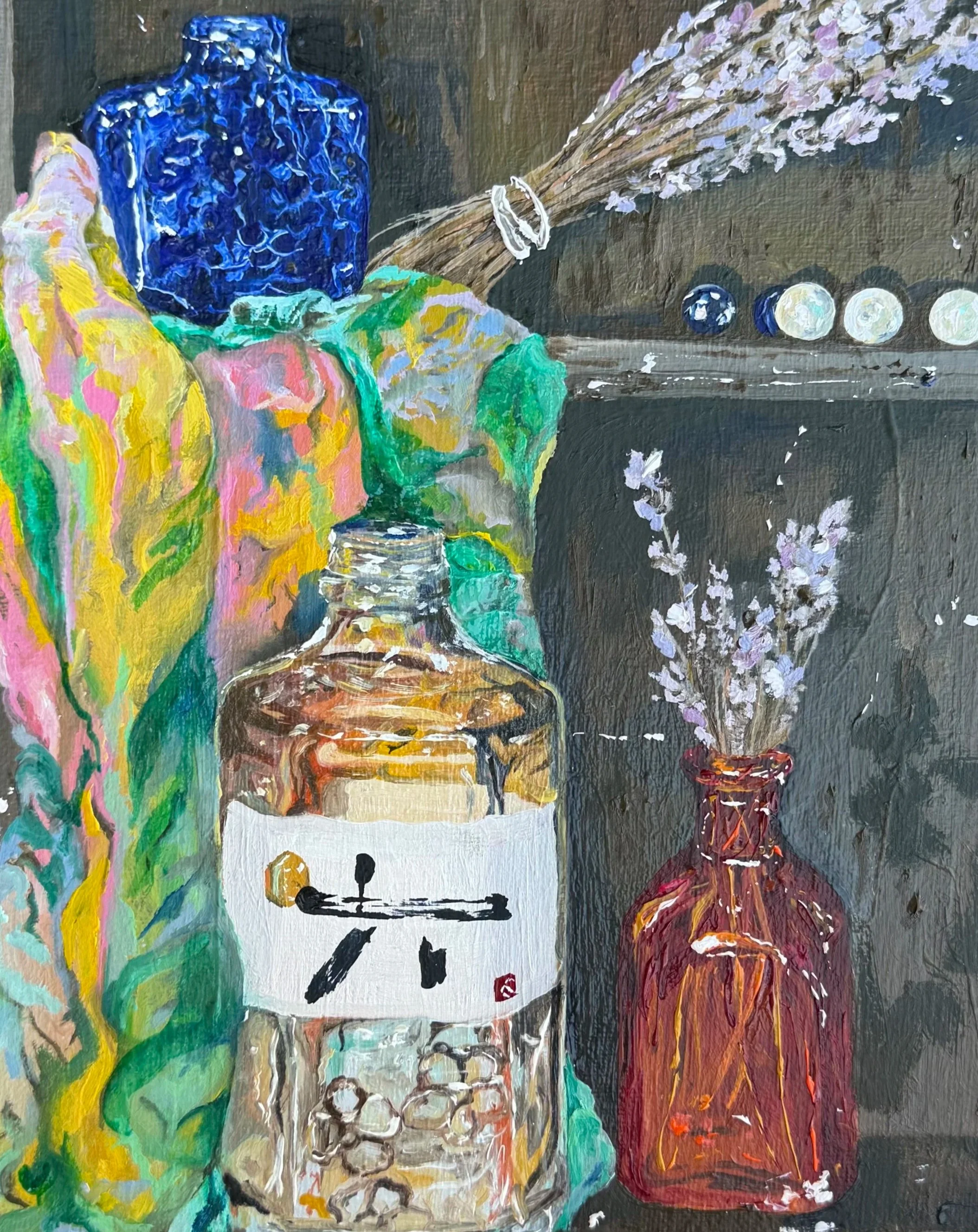 Still life of a blue vase with lavender flowers, a green and pink cloth, a white teapot with black handles and a red and orange glass vase, all painted on a dark background.
