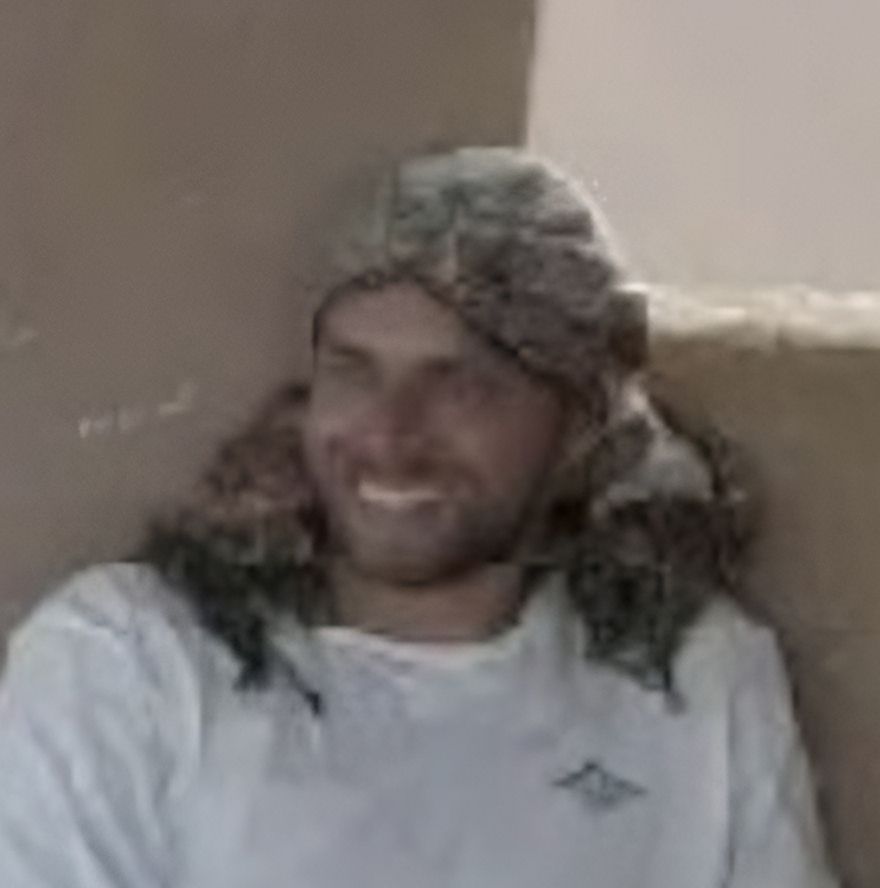 Persona con gorro y chaqueta, sonriendo, en un ambiente interior