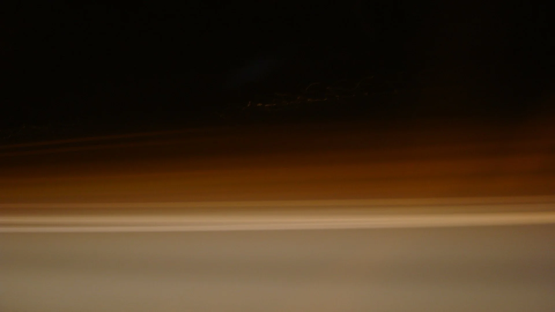 A blurred night scene with streaks of light and dark sky.