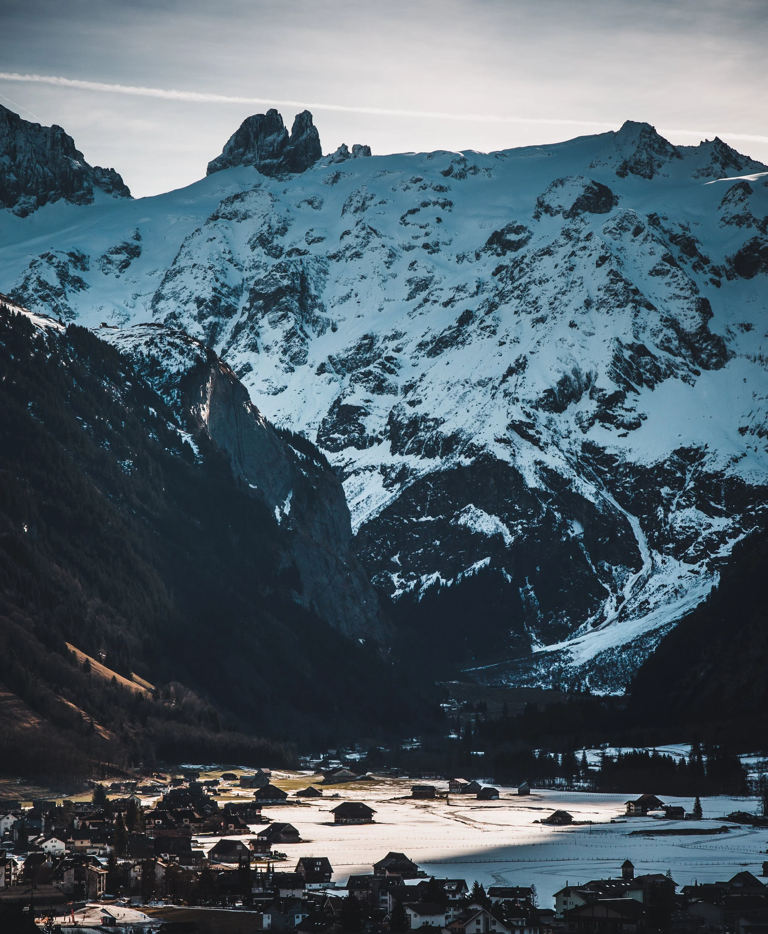 Snow-covered mountains overlooking a small village in a valley