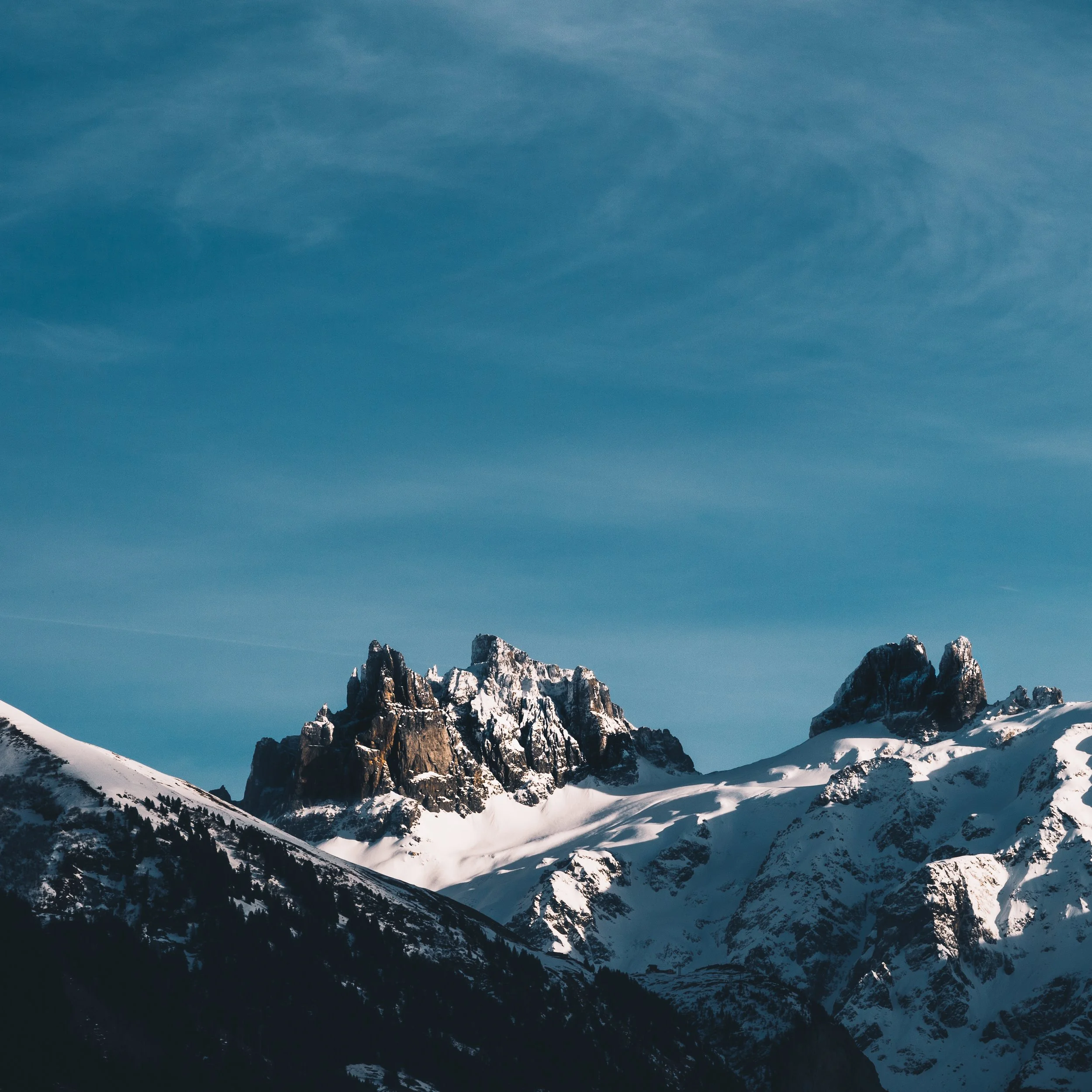 Snow-covered mountain peaks under a clear blue sky.