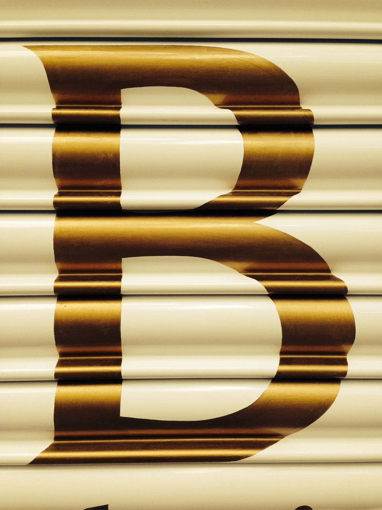 Large black and gold number 3 on a metallic beige background.