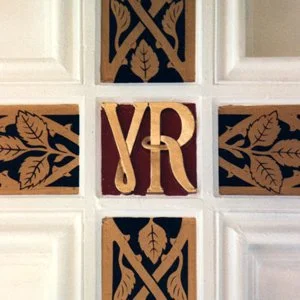 Decorative wall with wooden leaves design and gold initials YR in the center