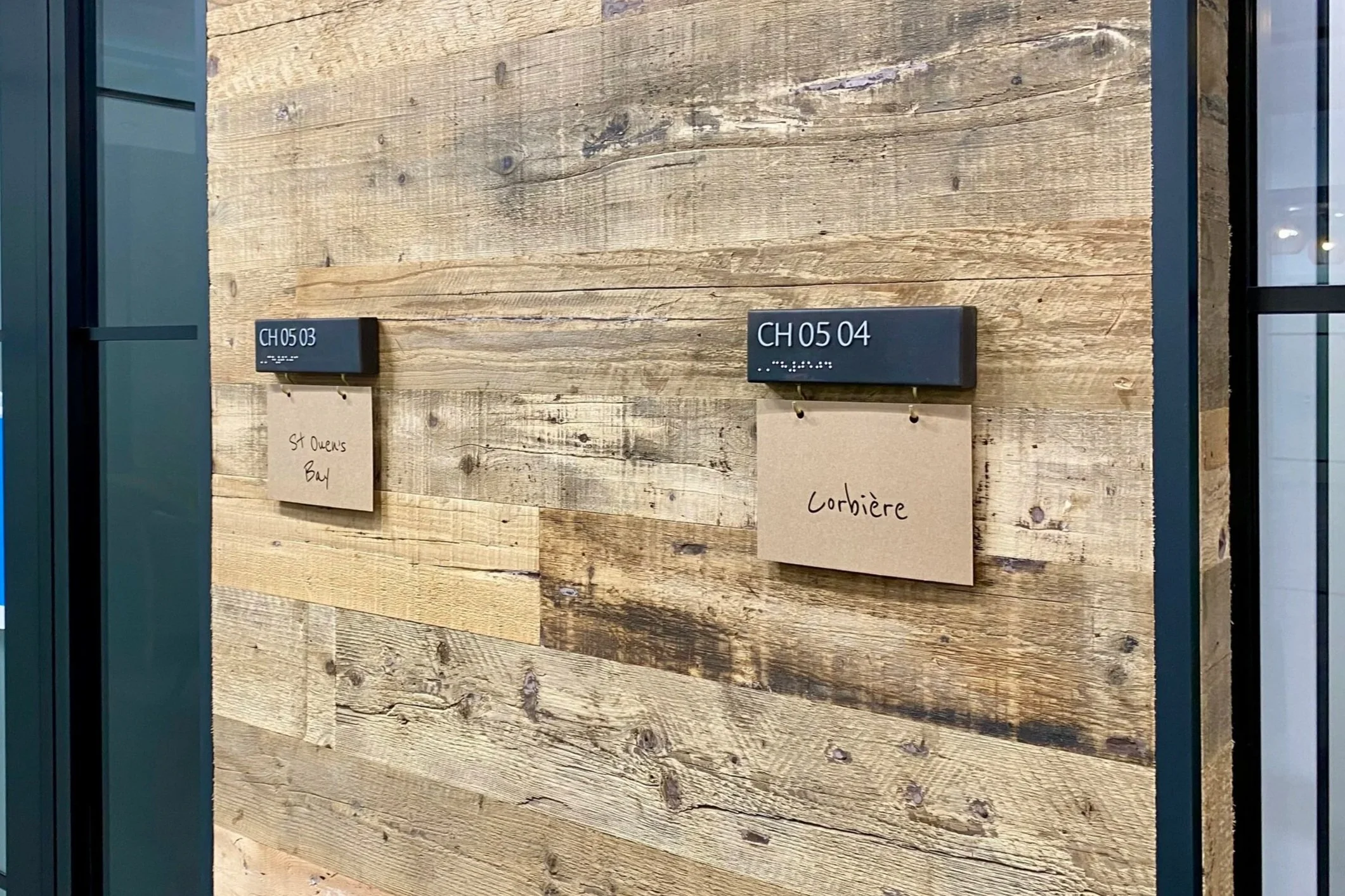 Two black signs with blue labels displaying