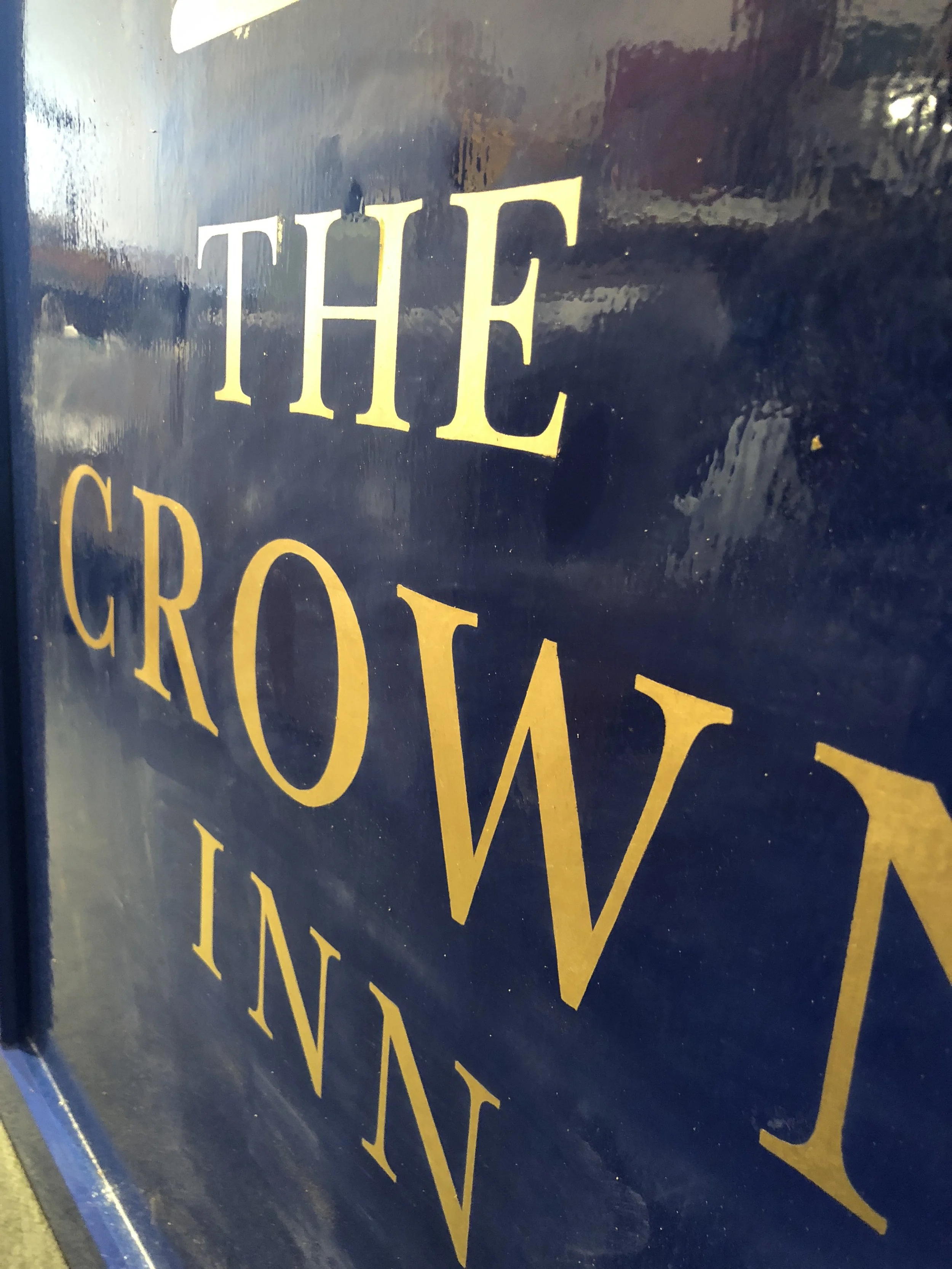 Close-up of a dark blue sign with gold and white text that reads 'THE GROWIN'.