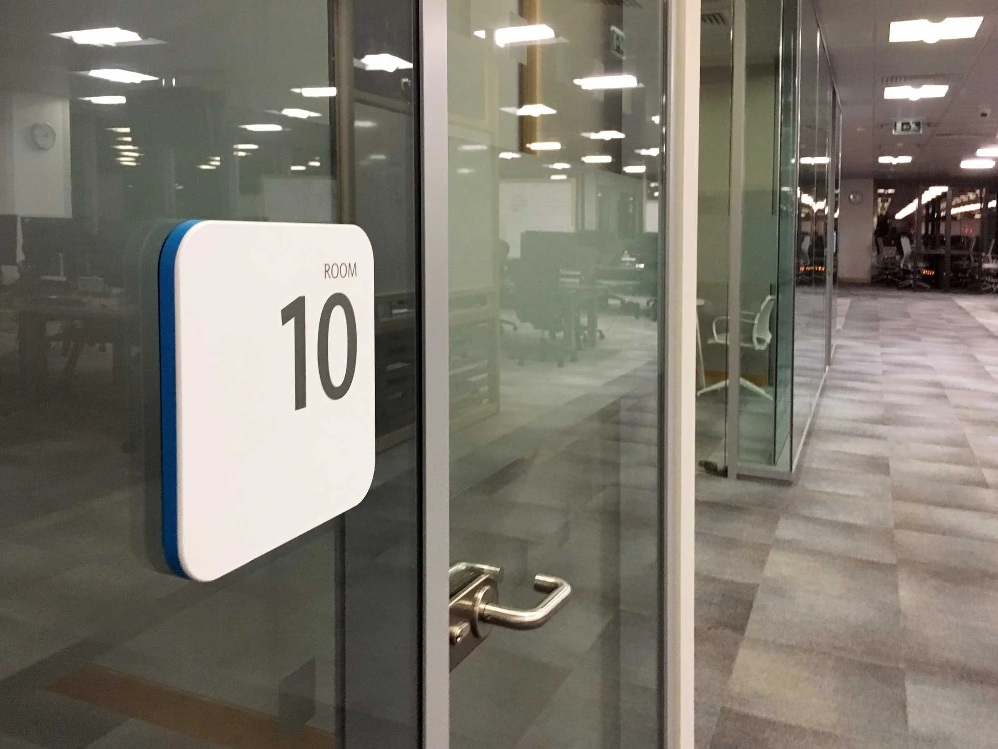 Glass door with a sign reading 'Room 10' in a modern office or conference center.