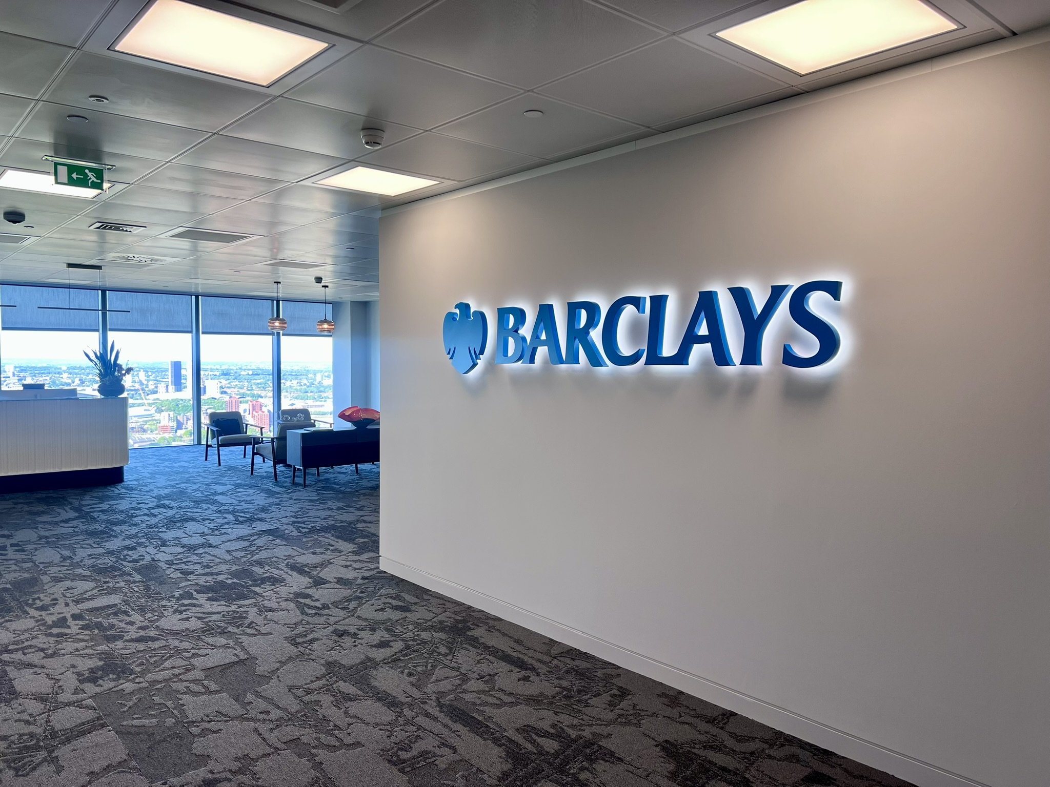 Interior of a modern office space with a halo illuminated Barclays sign