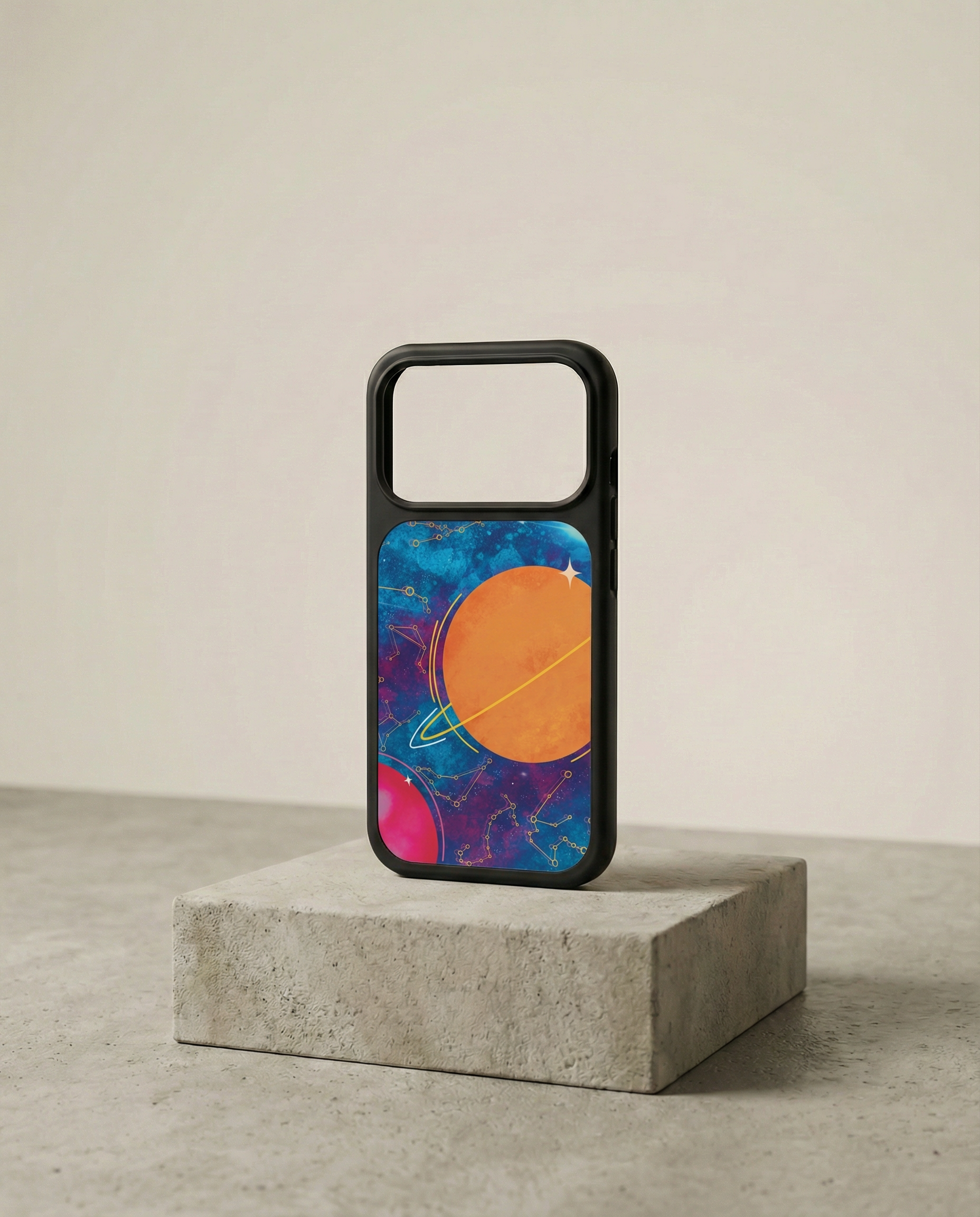 Smartphone case with space-themed design, featuring planets and stars, placed on a concrete block.