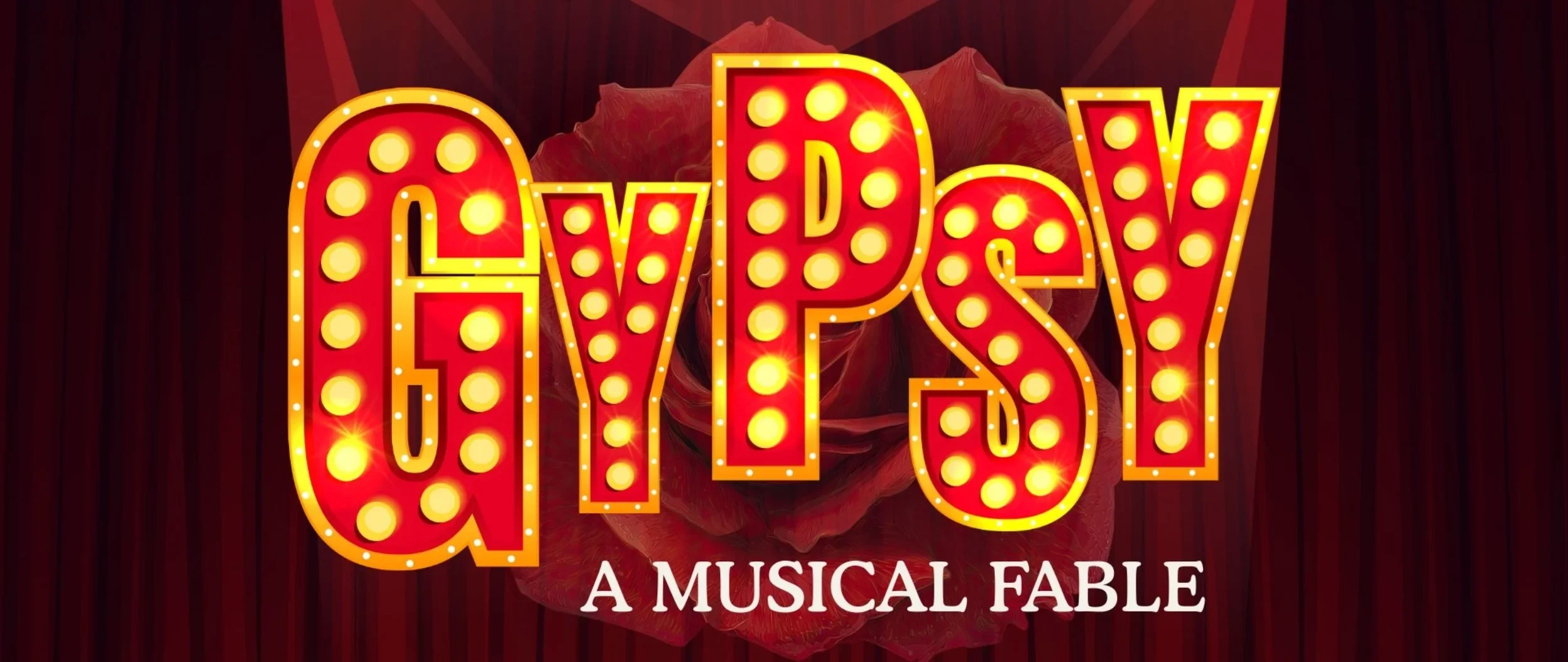 Bright marquee sign spelling 'QYPSY' with light bulbs, set against a dark background with a red rose in the background, and text below reading 'A Musical Fable'.