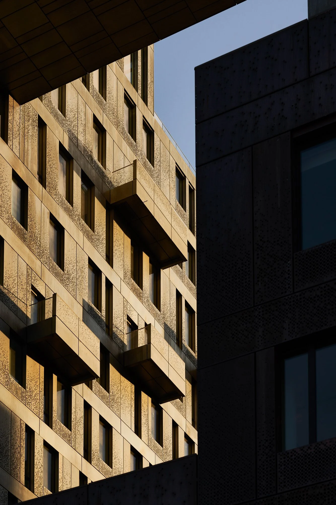Perforated zinc facade panels and cantilevered balconies at 325 Kent Ave. Specialty facade design and engineering by Studio North, Brooklyn, New York.