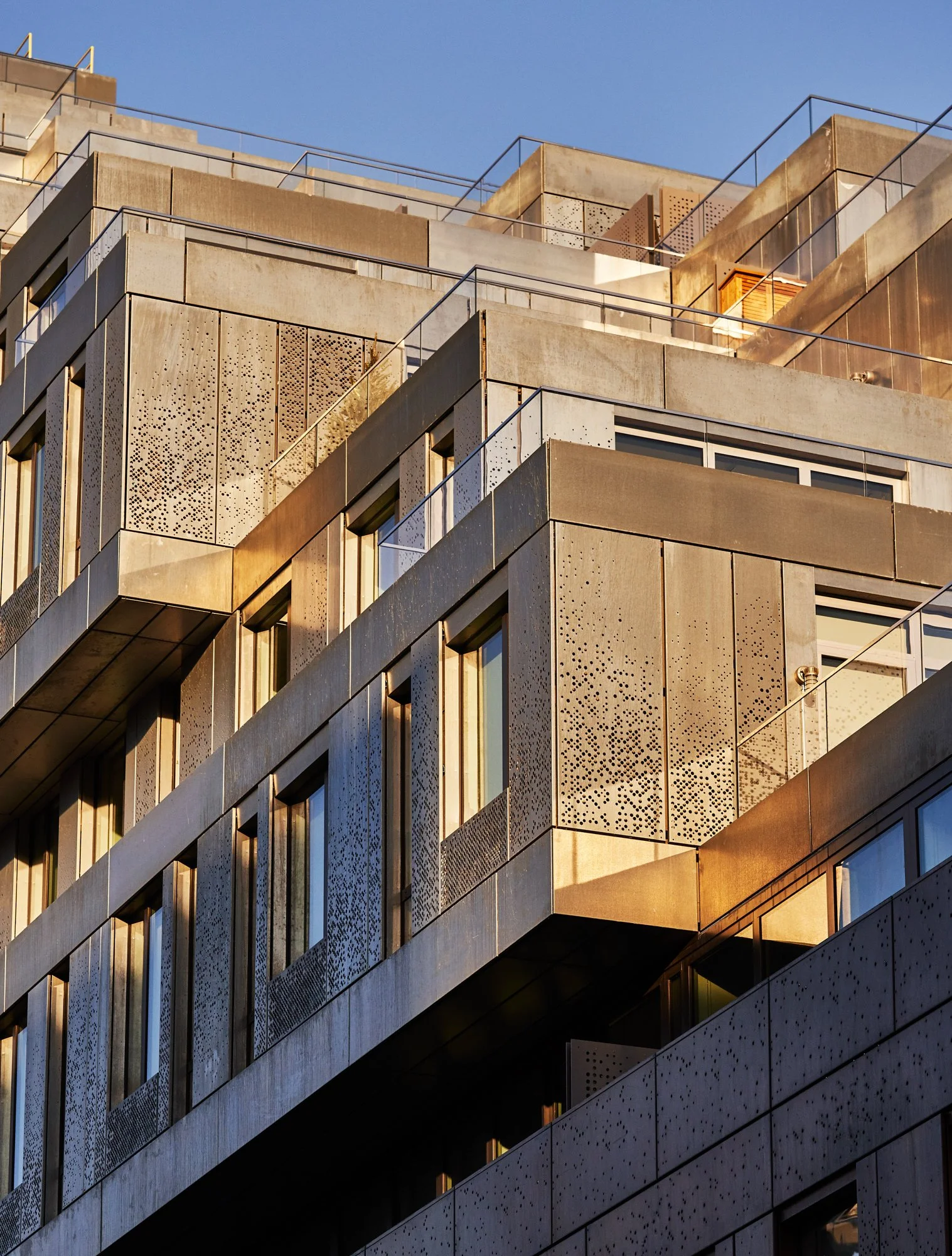 Perforated zinc cladding and rooftop terraces at 325 Kent Ave. Custom architectural metal facade design by Studio North for award winning Brooklyn waterfront residential tower.