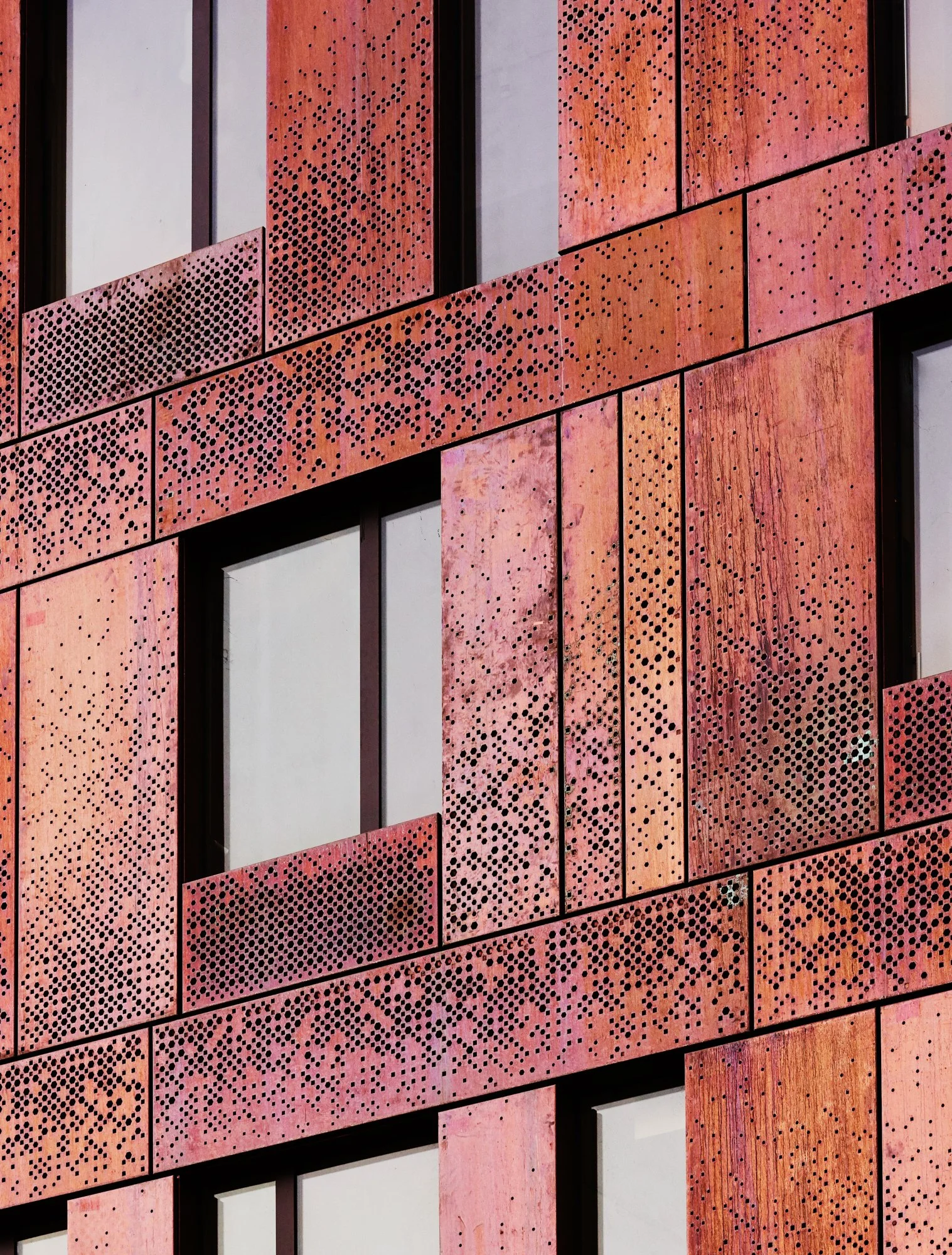 Custom perforated copper facade panels at 325 Kent Ave. Architectural metal cladding designed and manufactured by Studio North, New York facade designers, for Two Trees Management.