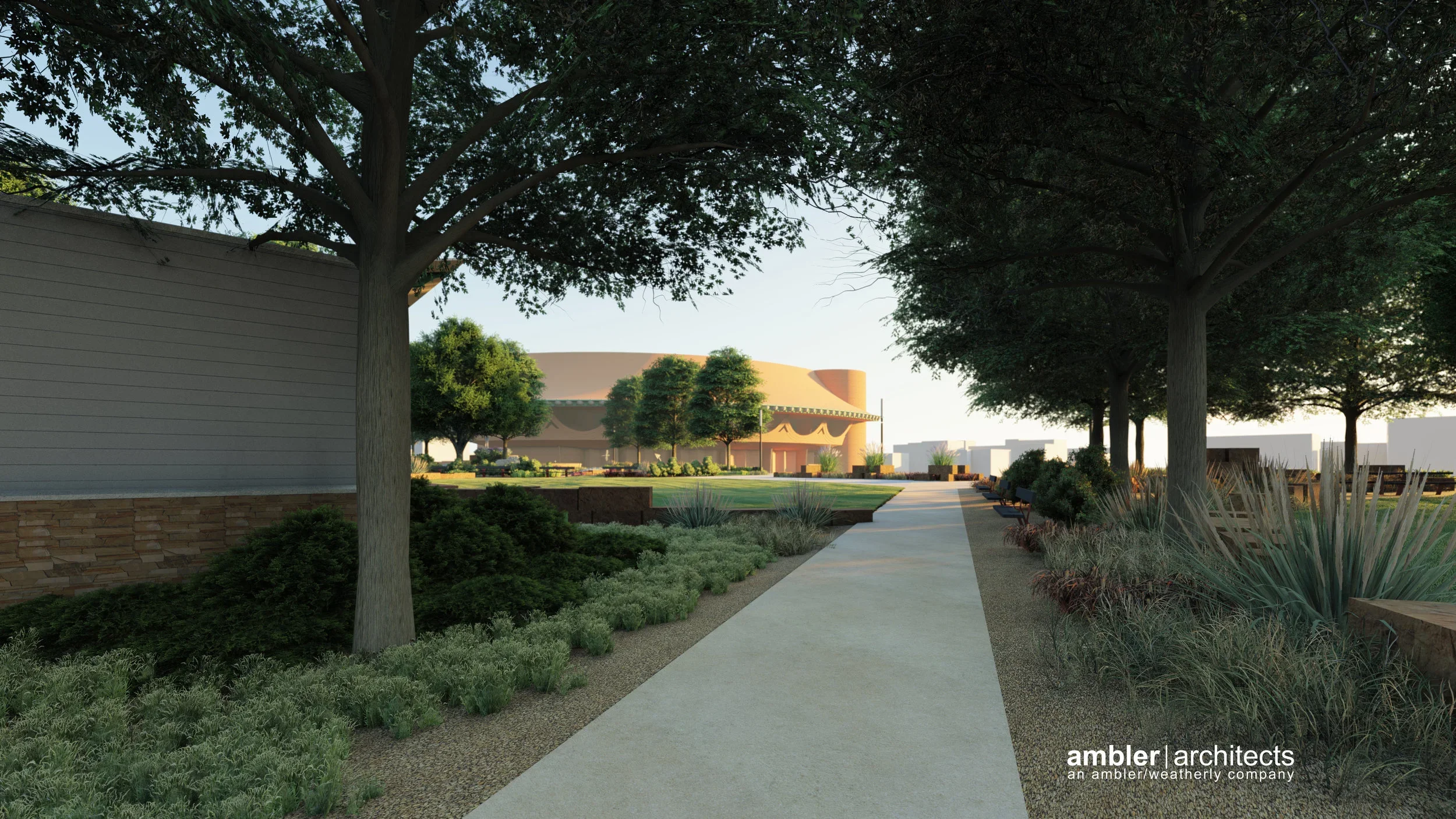 A landscaped park with a pathway, trees, bushes, and benches, leading to a modern, rounded building in the background during daytime.