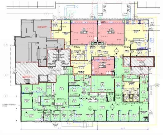 A detailed architectural floor plan with various rooms and sections outlined in different colors, including pink, green, yellow, and gray, indicating different areas or zones.