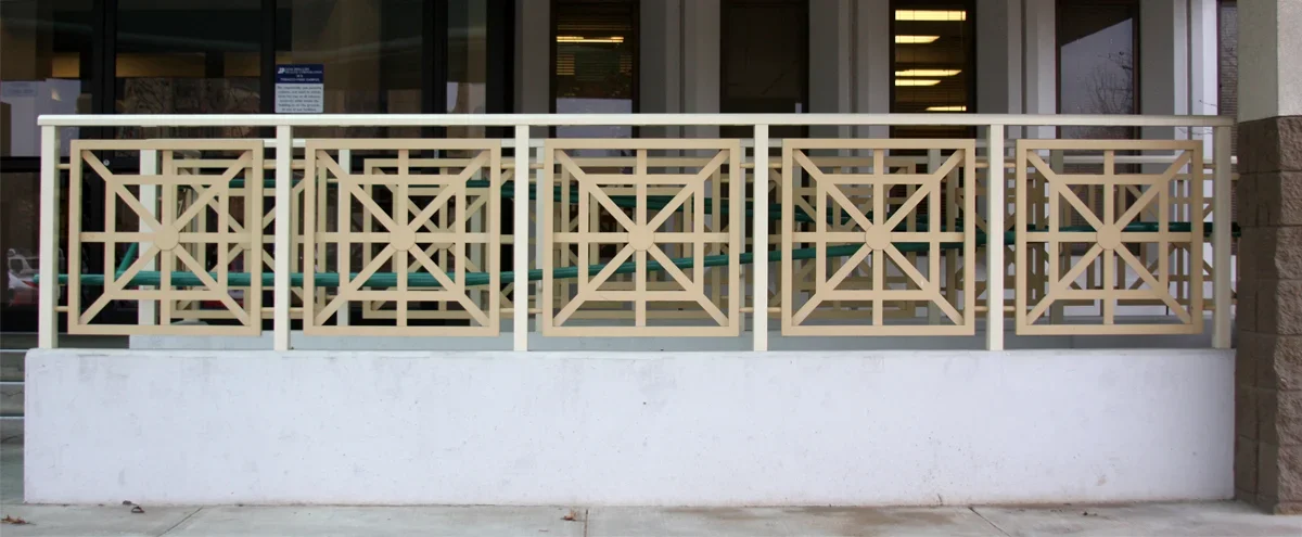 A beige decorative railing with square patterns surrounds a small outdoor patio area in front of Jane Phillips Surgical Hospital.