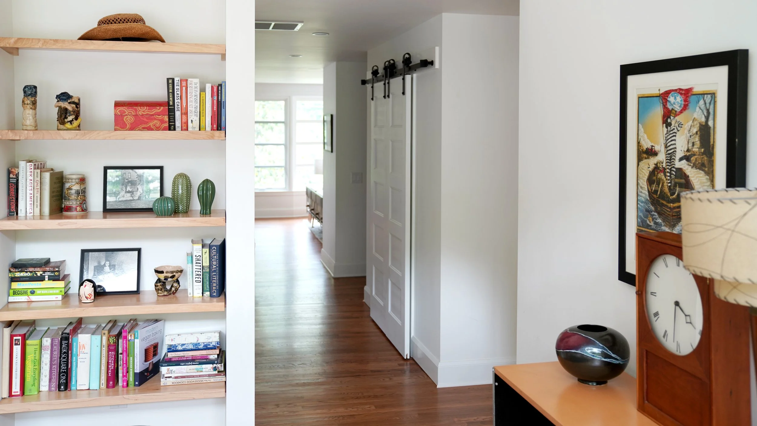 Red Oak hallway with custom built shelving and sliding door.