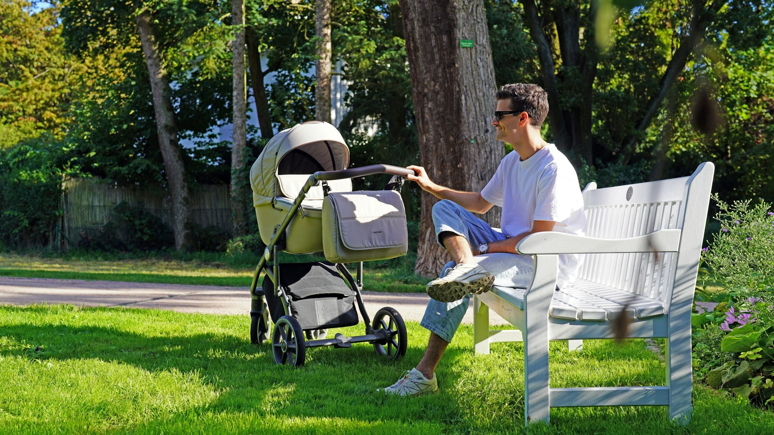 dad and baby stroller sitting near a bench