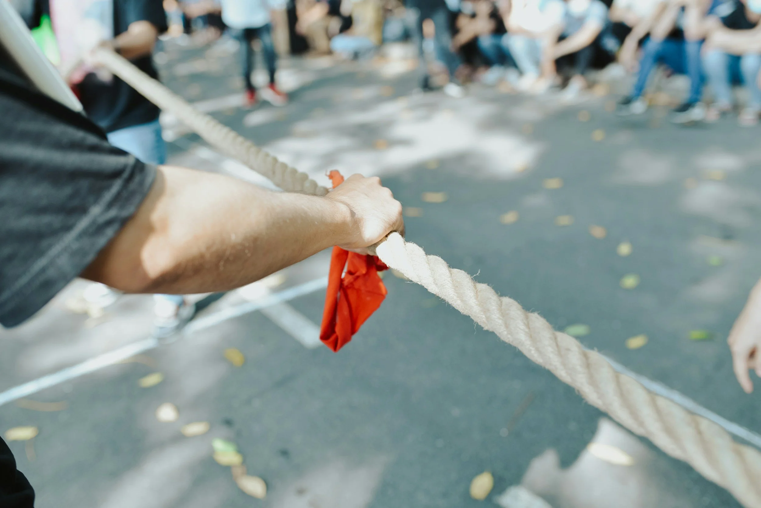 A tug of war rope with a piece of red material knotted in the centre