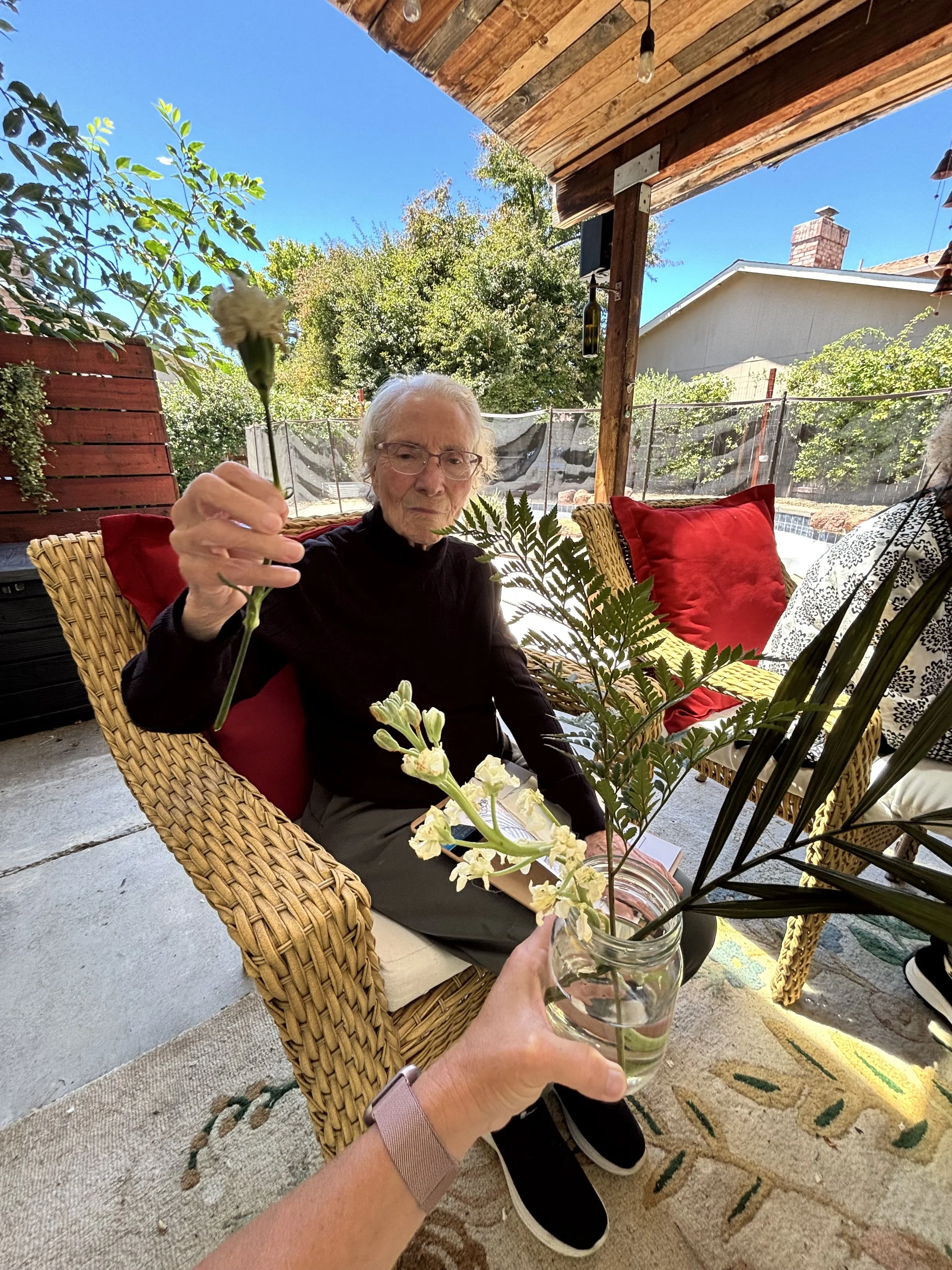 Seniors enjoying flower arranging and a creative activity at Rebekah’s Retreat adult day care program in Fairfield, California.
