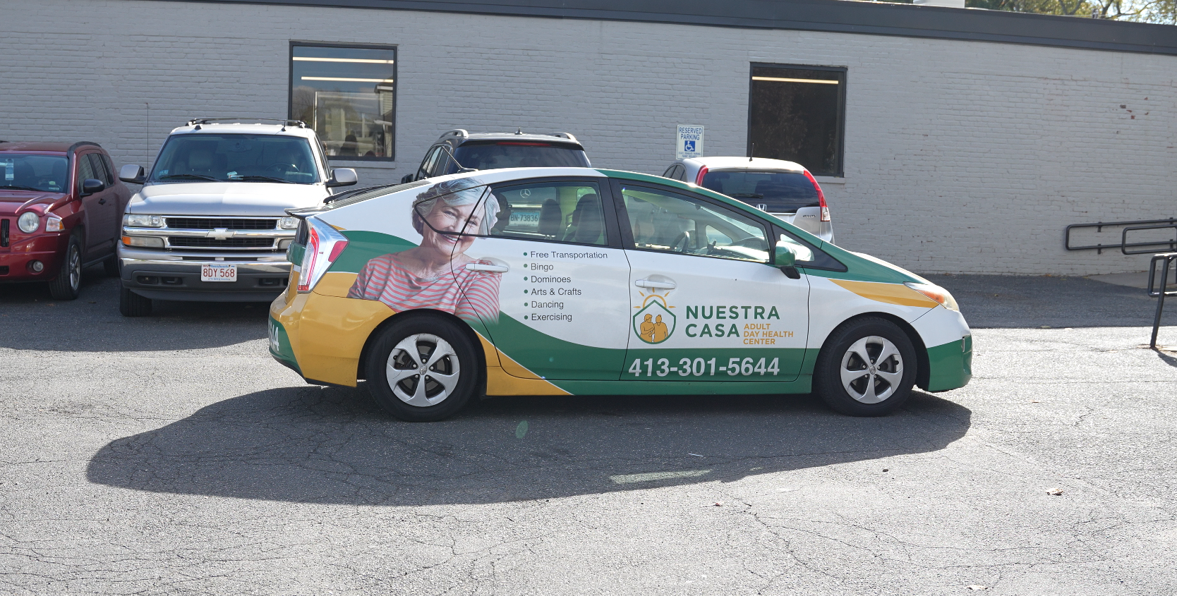 Scenic landscape of a lake surrounded by rolling hills and mountains in the background under cloudy sky.