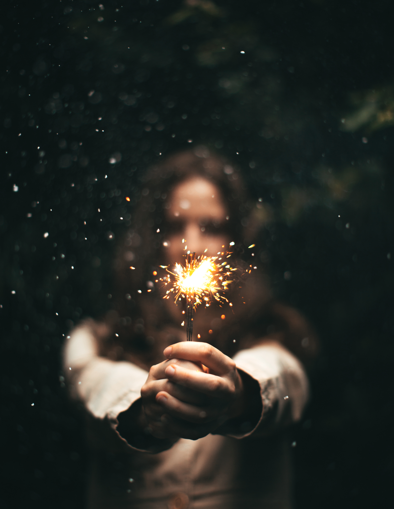 Woman holding a sparkler in the dark, representing hope and healing through anxiety therapy in Michigan