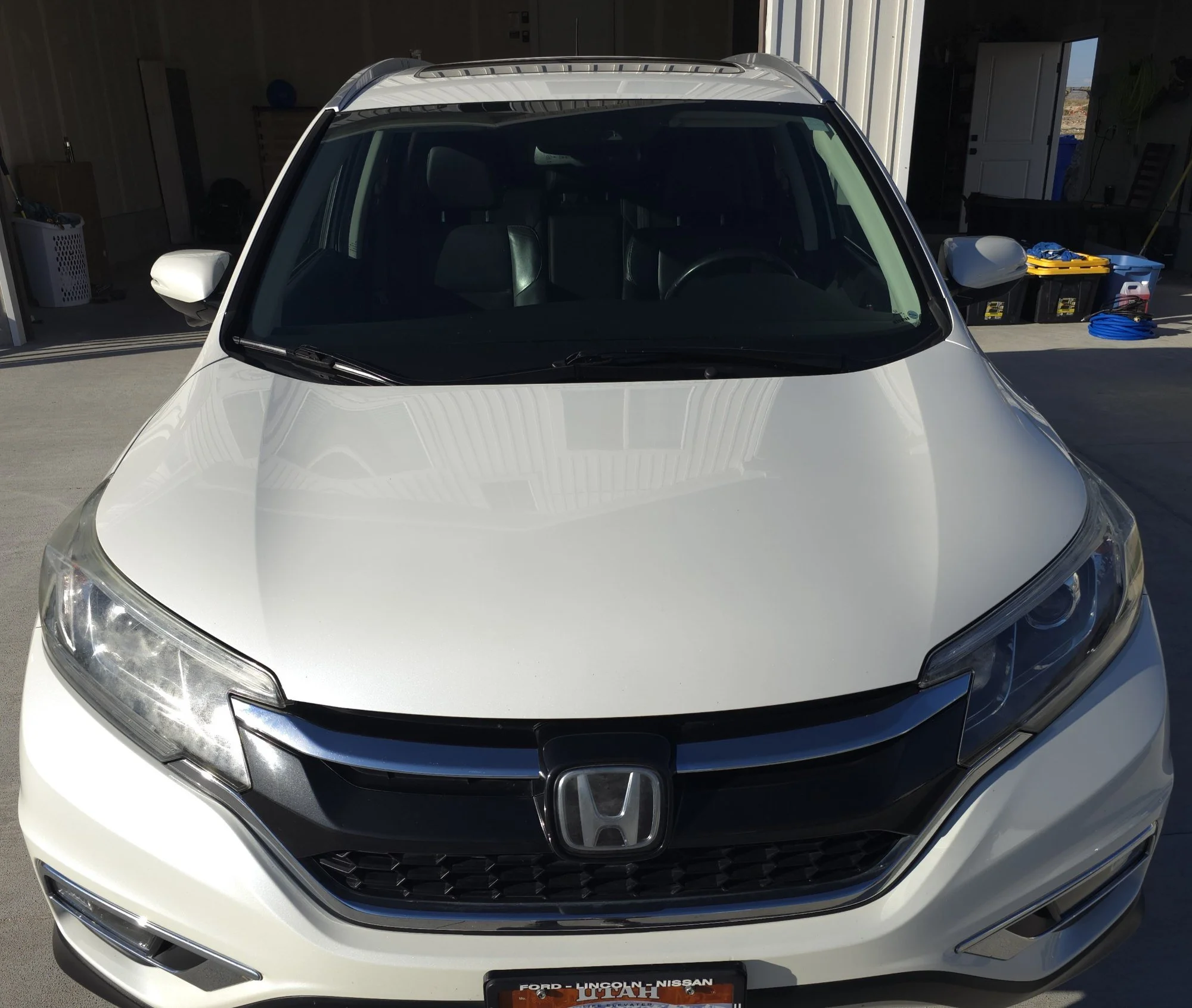 Front view of a white Honda SUV parked in a garage.