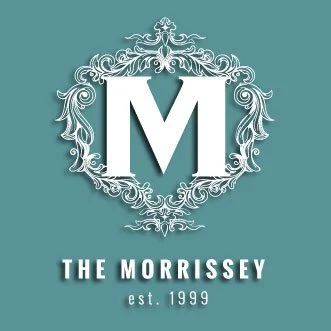 Logo with a large letter 'M' inside a decorative frame, with text below reading 'The Morrissey' and 'est. 1999', on a teal background.
