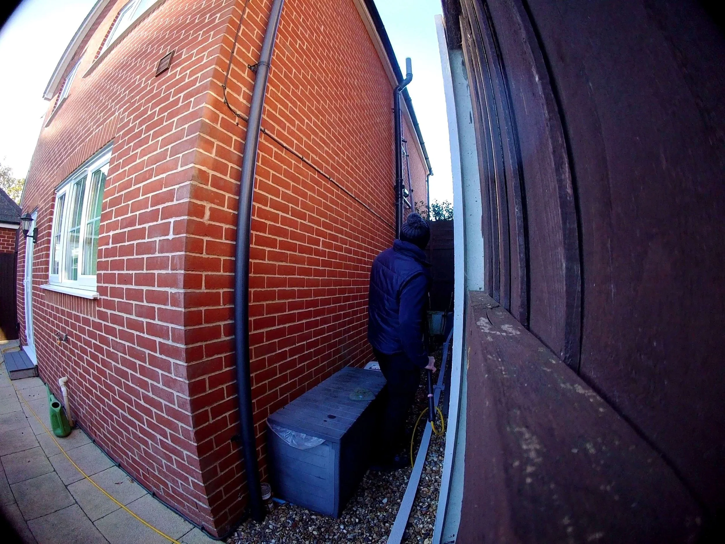 Reaching a difficult high window in a narrow alley using water fed pole in Colchester.