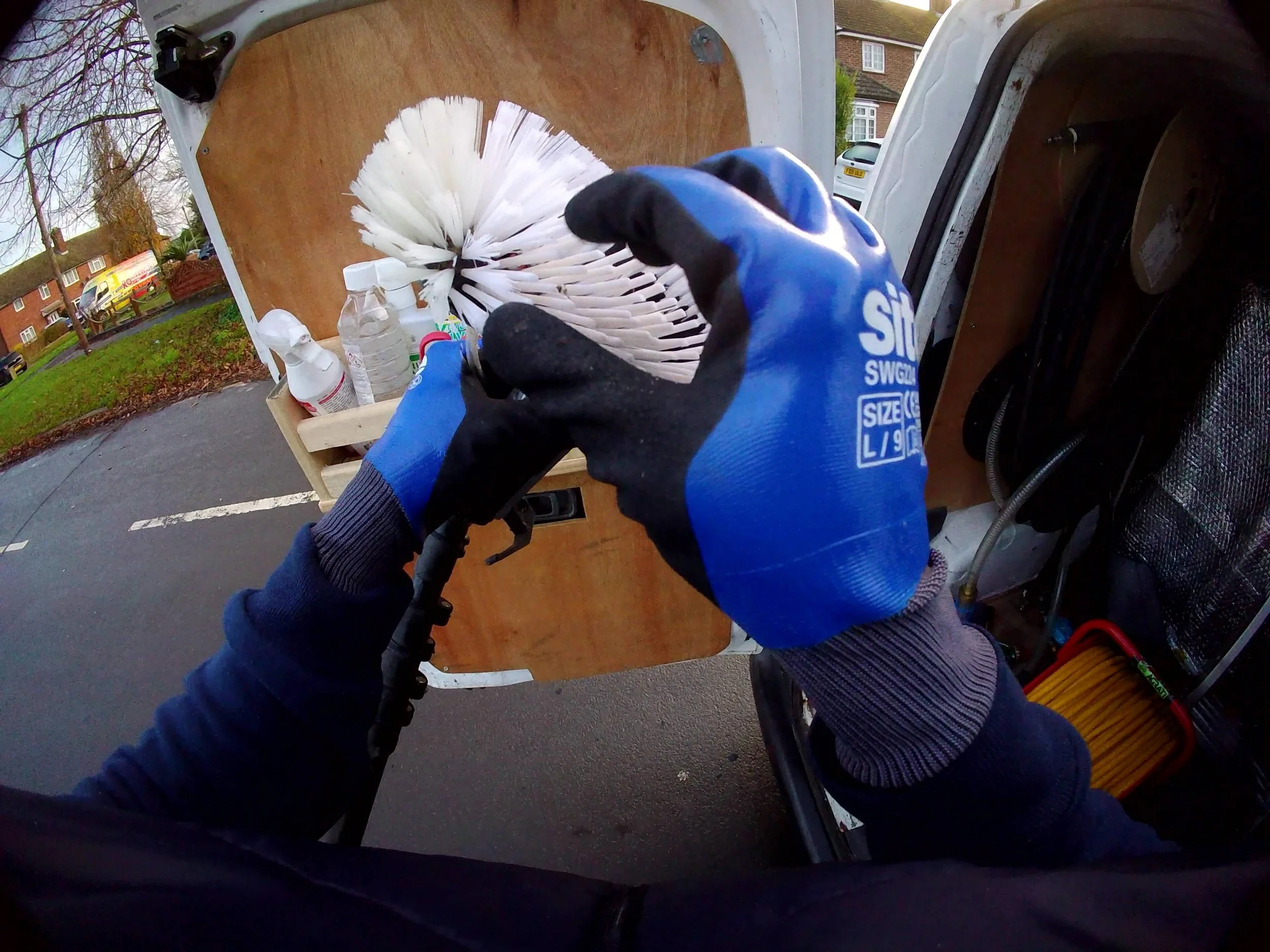 Checking soft bristles on water fed pole brush for scratch-free window cleaning.