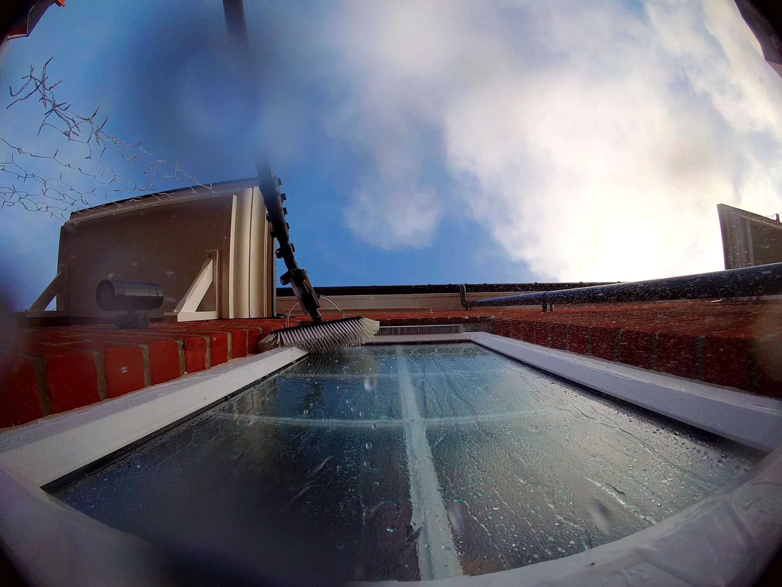 Water fed pole brush cleaning the side of window frames and vents in Colchester.