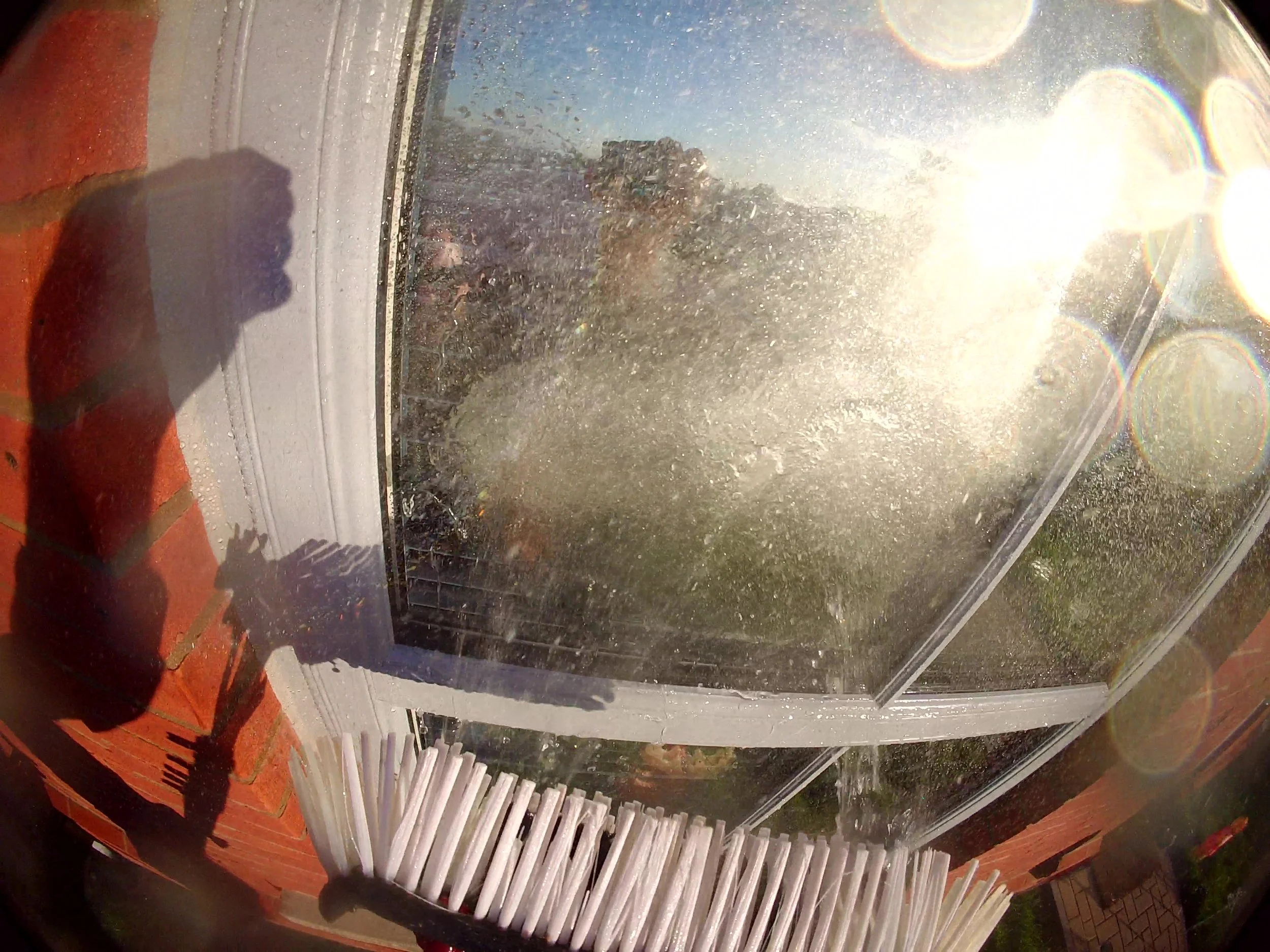 Close up of red fan jets on water fed pole brush for window cleaning Essex.