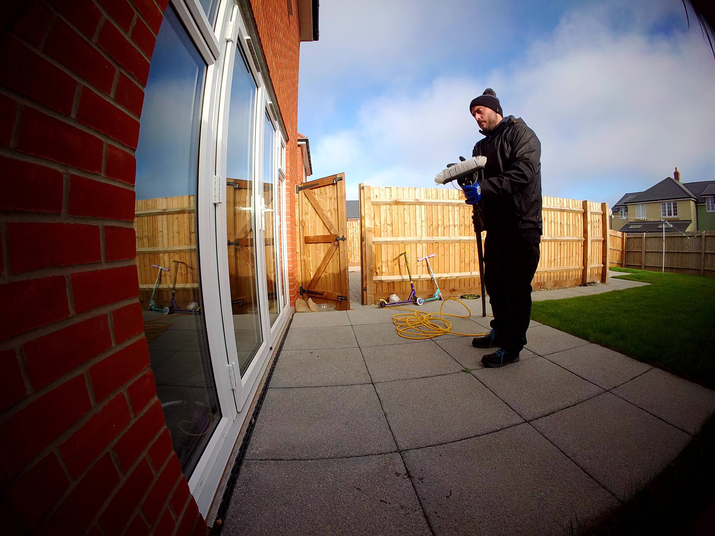 Checking window cleaning brush for grit and cobwebs to prevent scratches during cleaning.