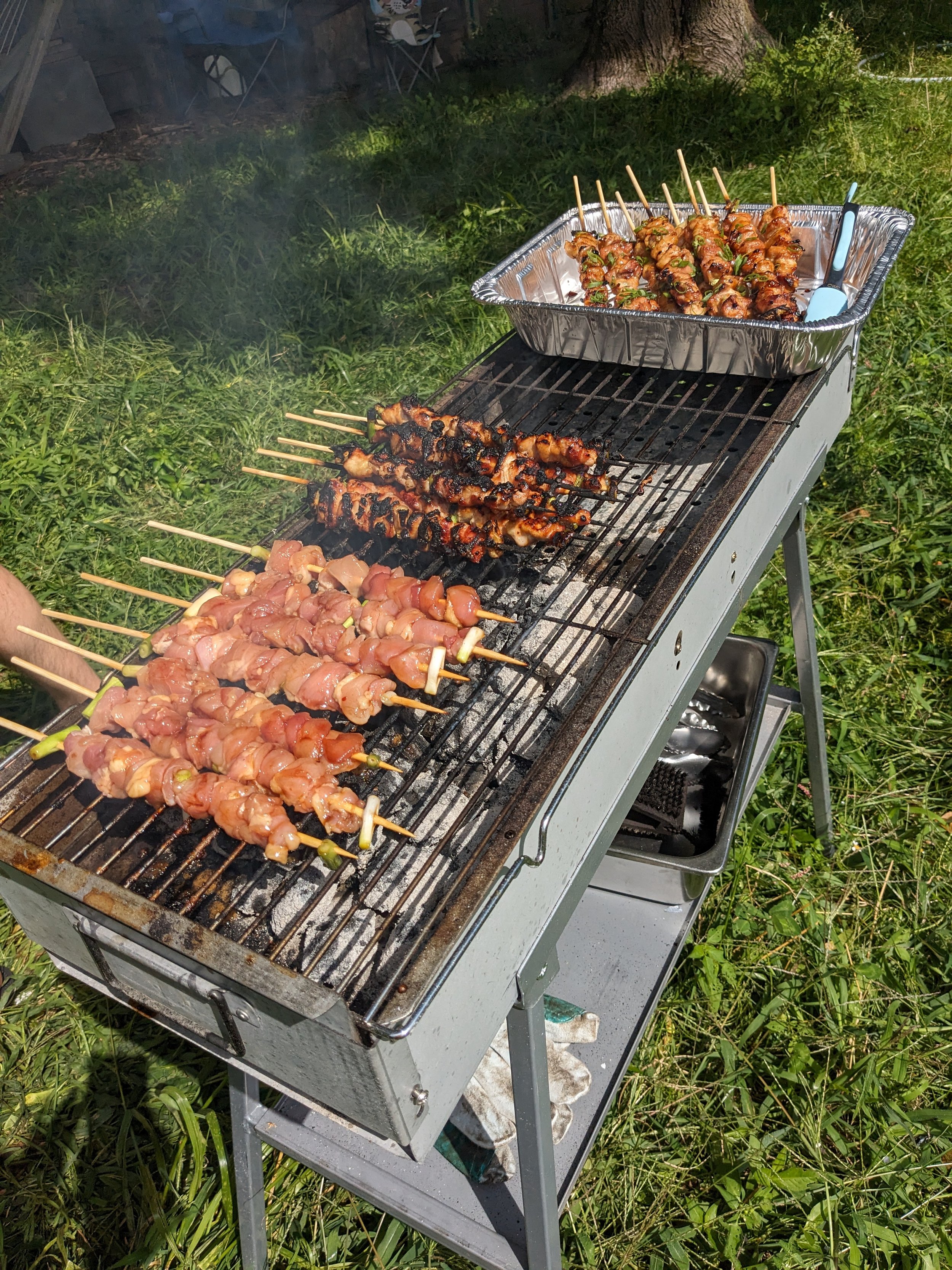Chicken yakitori cooking over charcoal in the summer