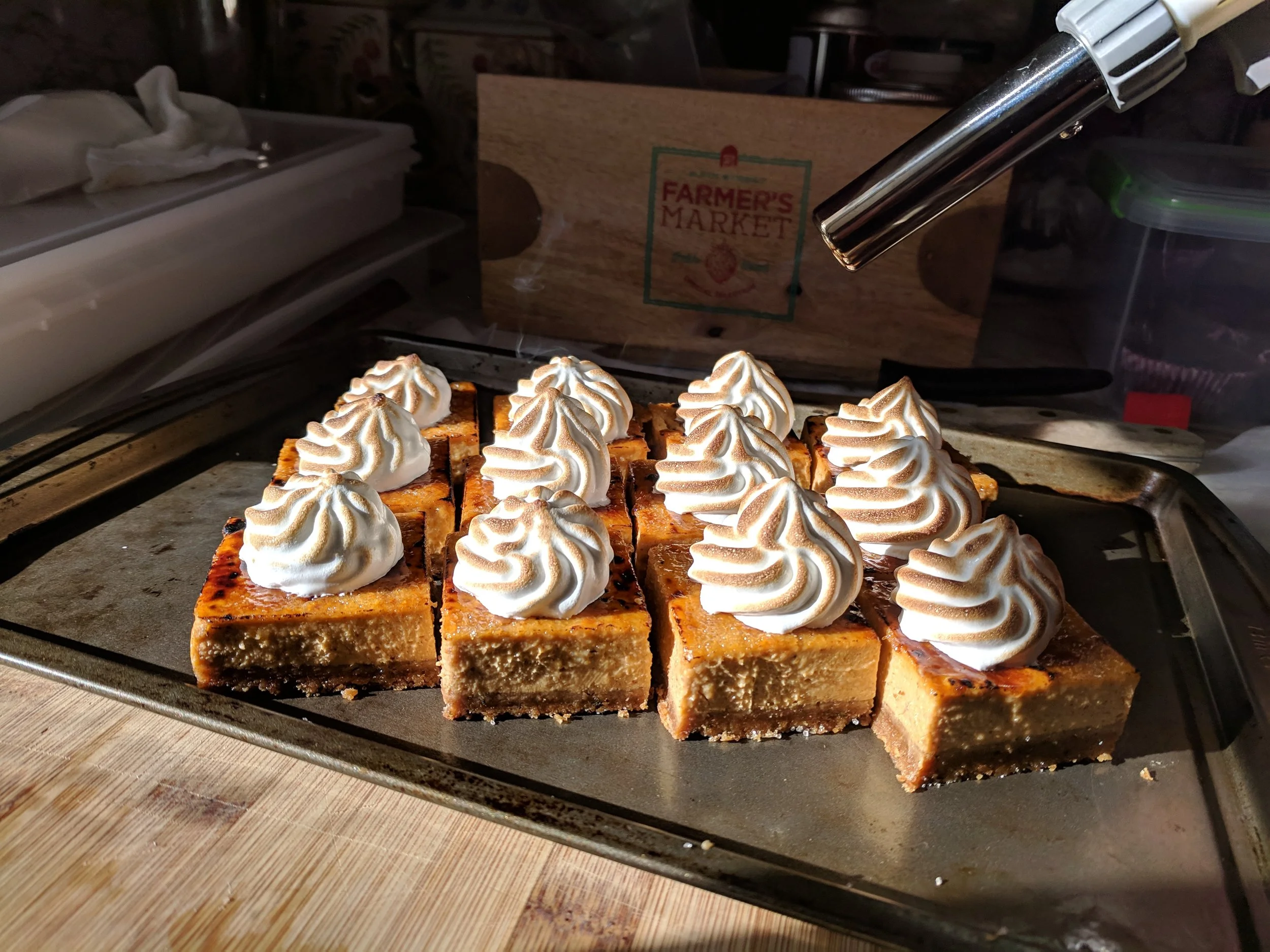 A platter of pumpkin cheesecake being bruleed
