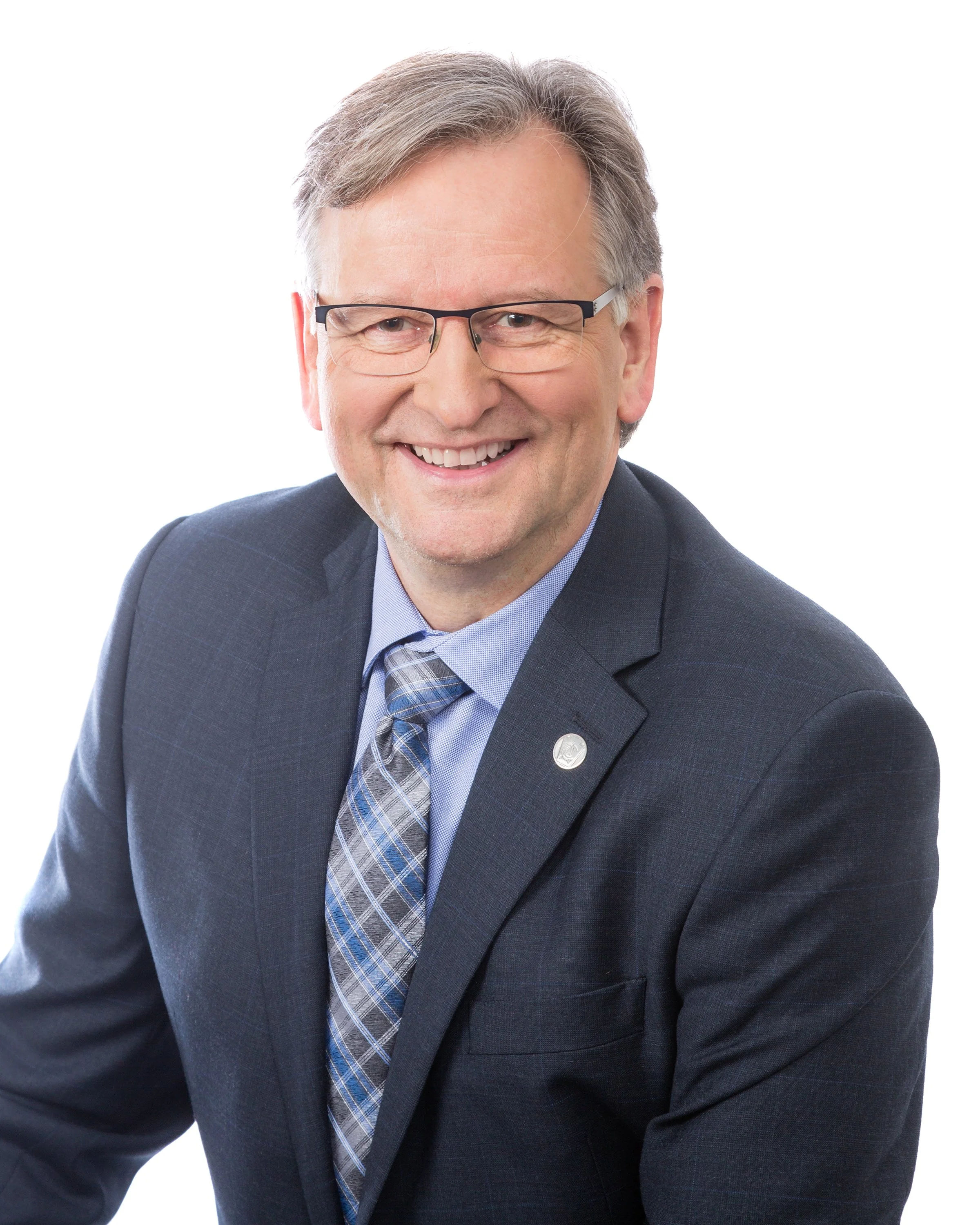 John Bockstael with glasses in a suit and tie, posing against a white background.