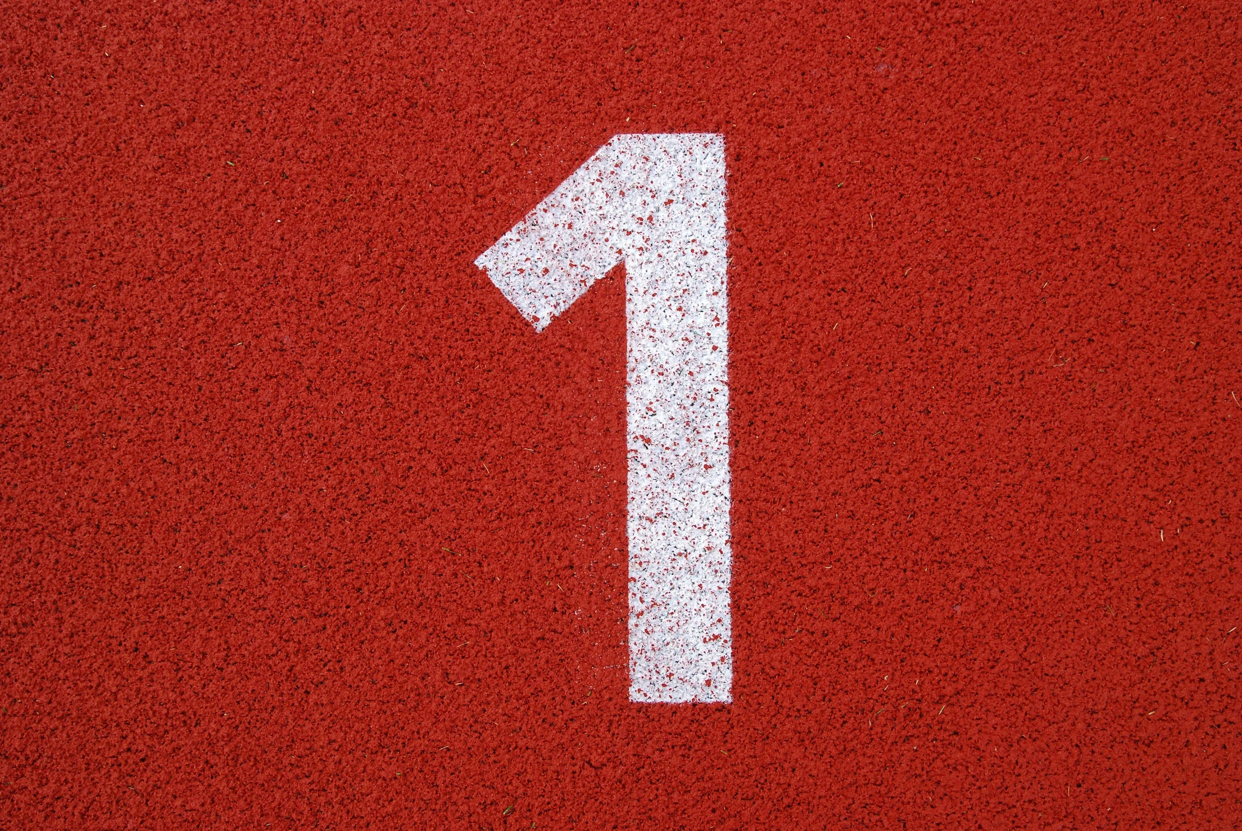 White number one painted on a red running track