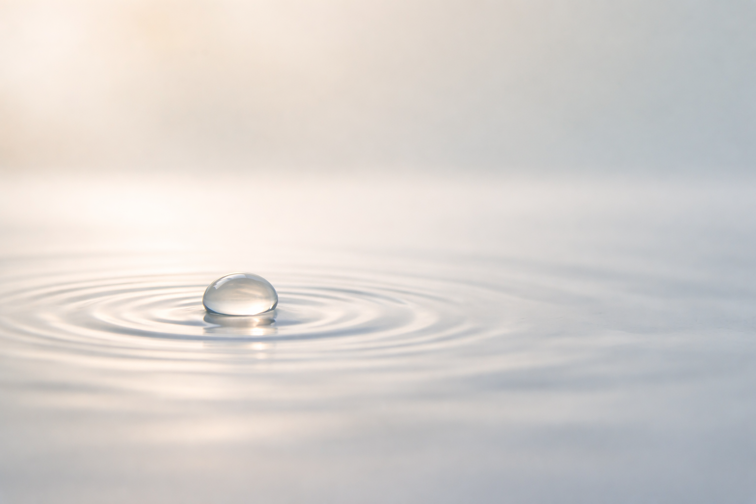 Su yüzeyine düşen bir su damlası ve etrafındaki halka dalgaları.