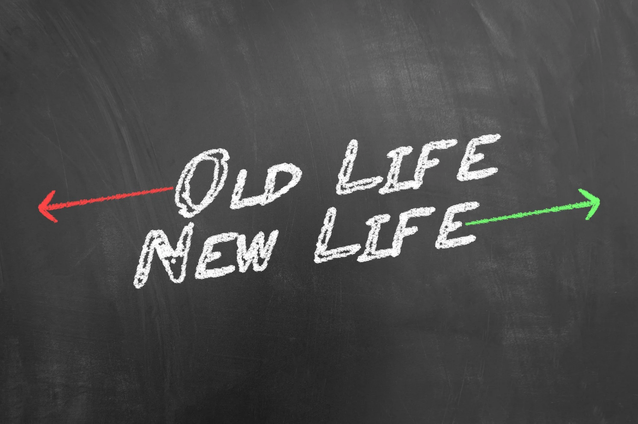 Chalkboard with the words 'Old Life' written in white chalk and an arrow pointing left, and 'New Life' with an arrow pointing right.