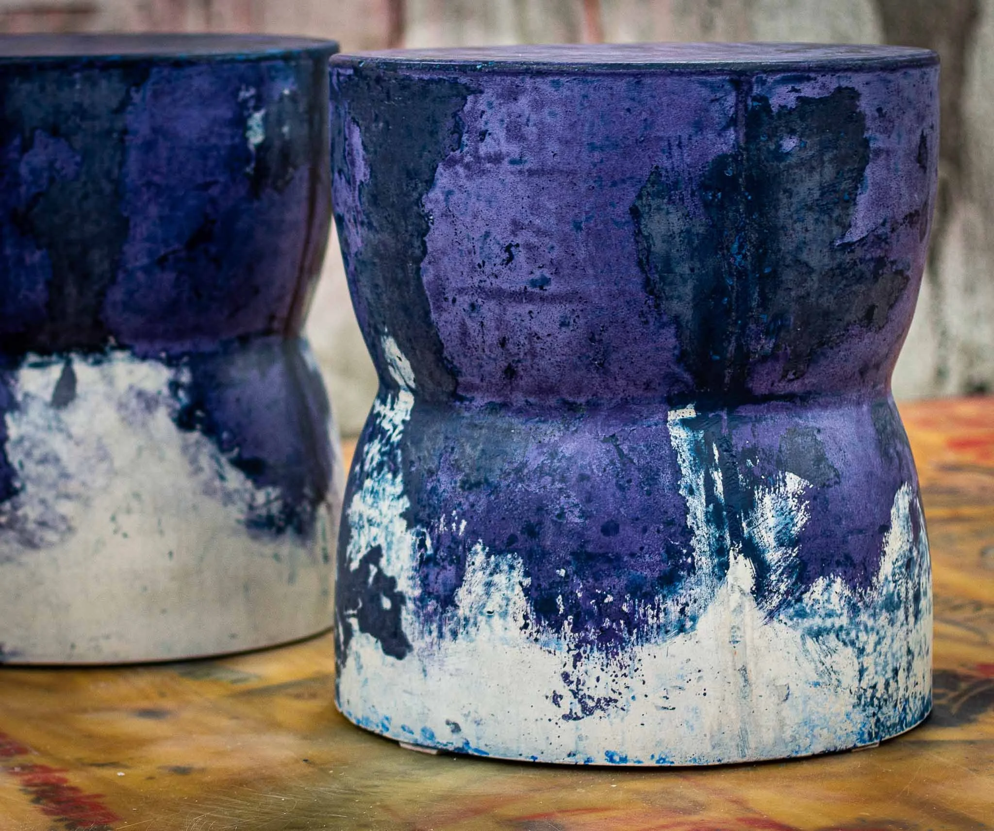 Sculptural concrete side table with a cinched waistline, blending deep indigo and cobalt tones into white at the base