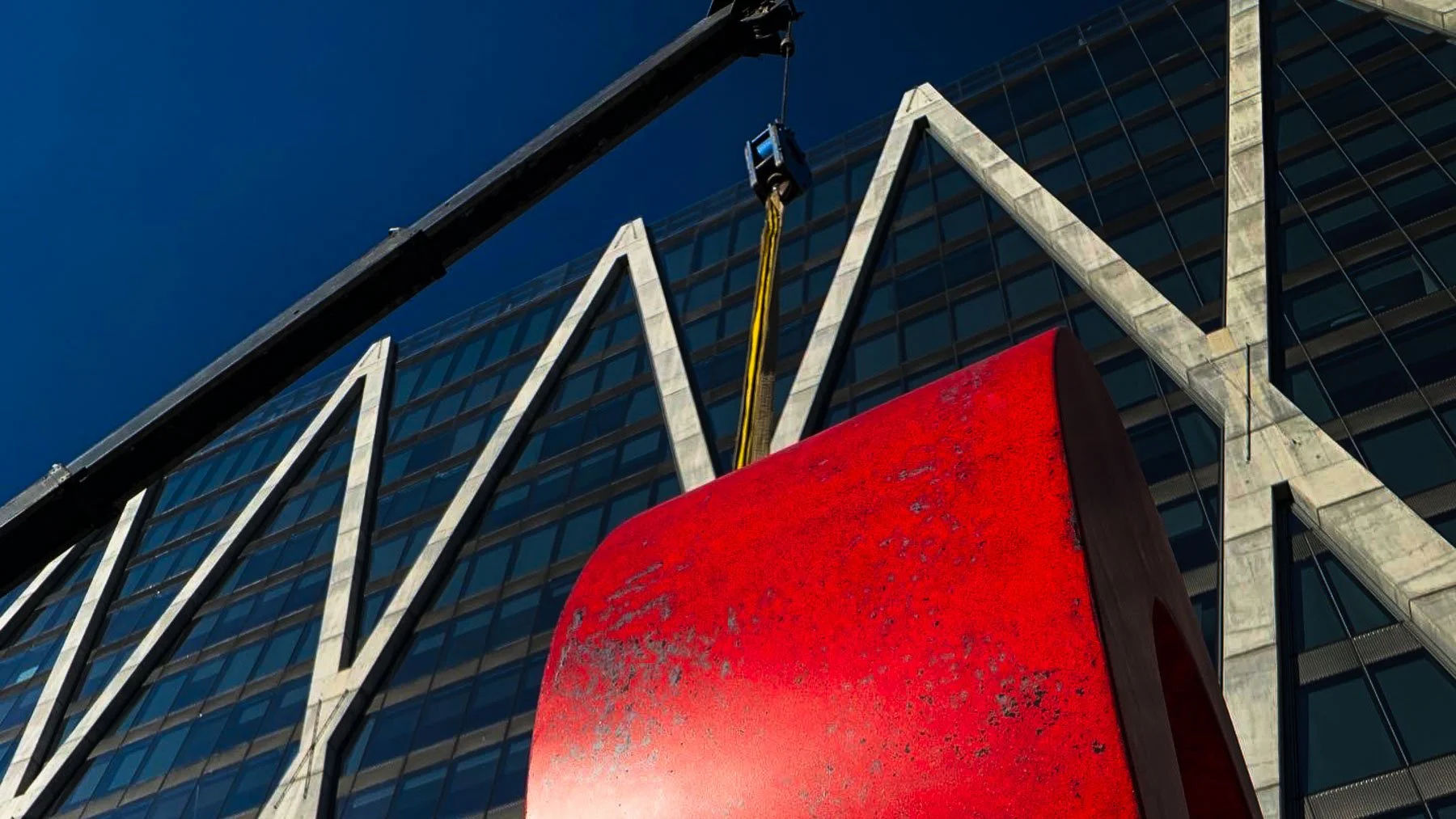 Low-angle close-up of the red terrazzo O from Dylan Myers’ monumental LOVE sculpture during installation in Reston, Virginia.