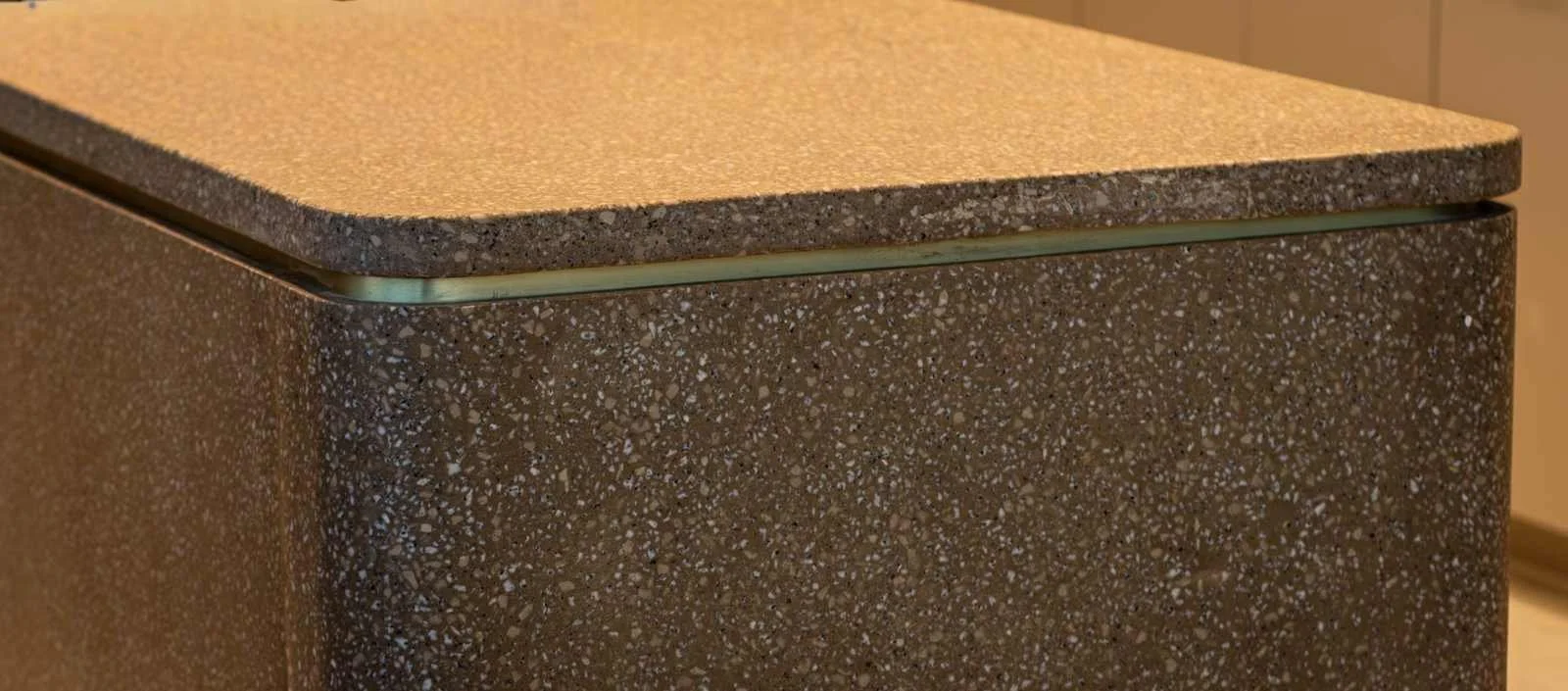 Custom cast concrete countertop with exposed aggregate finish and softly rounded edges.