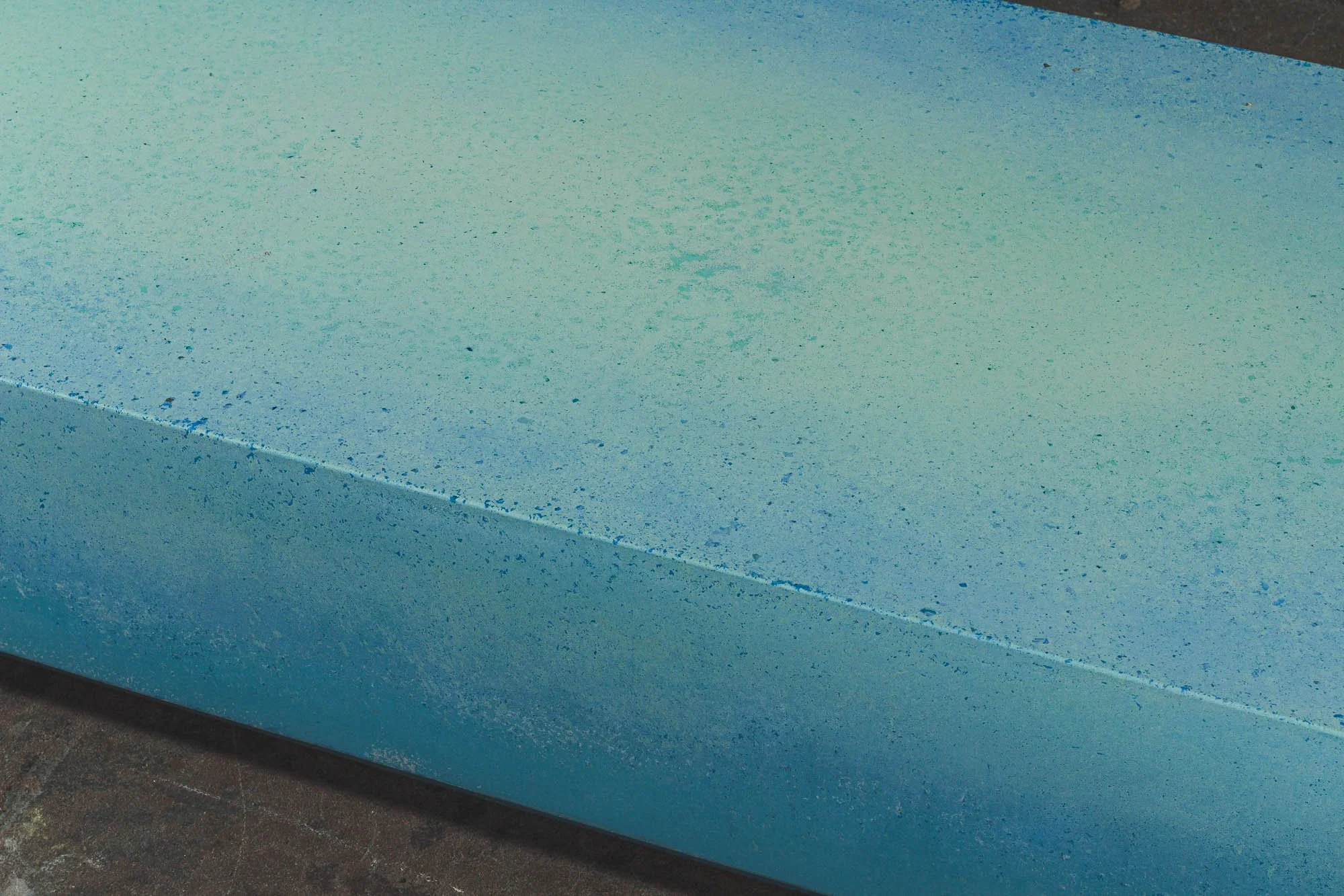 Chunk of Turquoise concrete artifact with color-shifted mineral pigments and polished edge — The Concrete Anomaly.