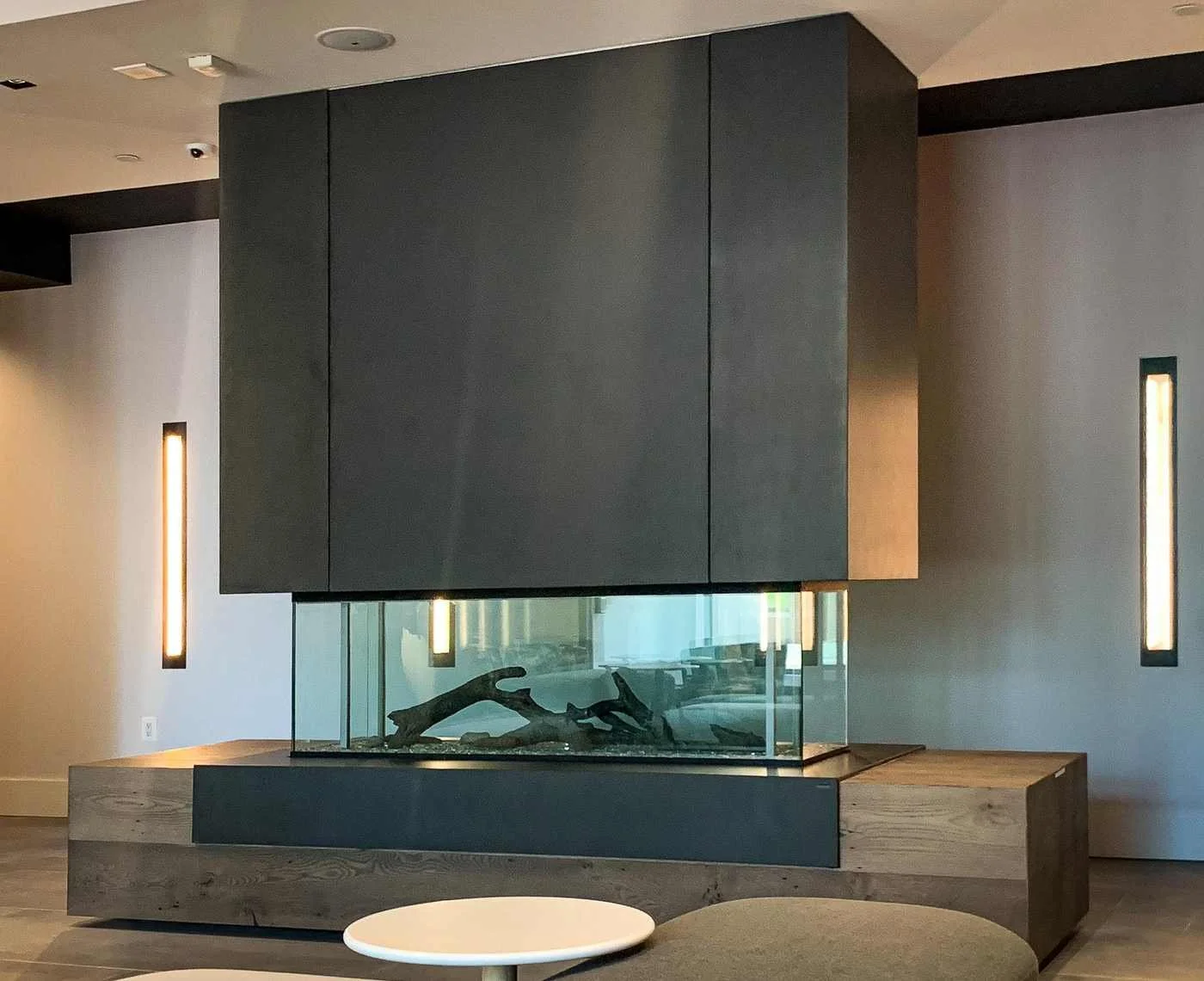 Custom cast concrete fireplace surround and hearth integrated into a modern interior with glass-enclosed fire feature.
