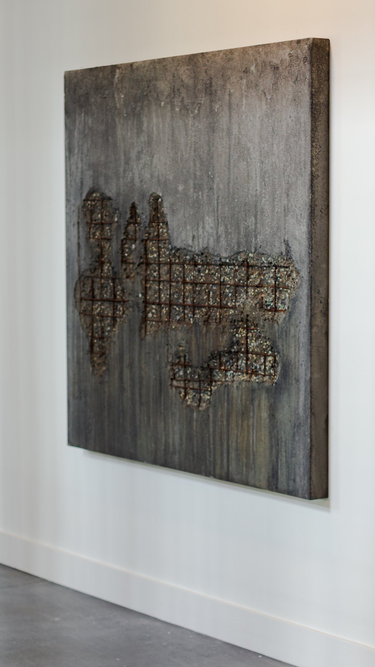 Concrete artifact panel with exposed steel lattice, aggregate texture, and oxidized surface by The Concrete Anomaly.
