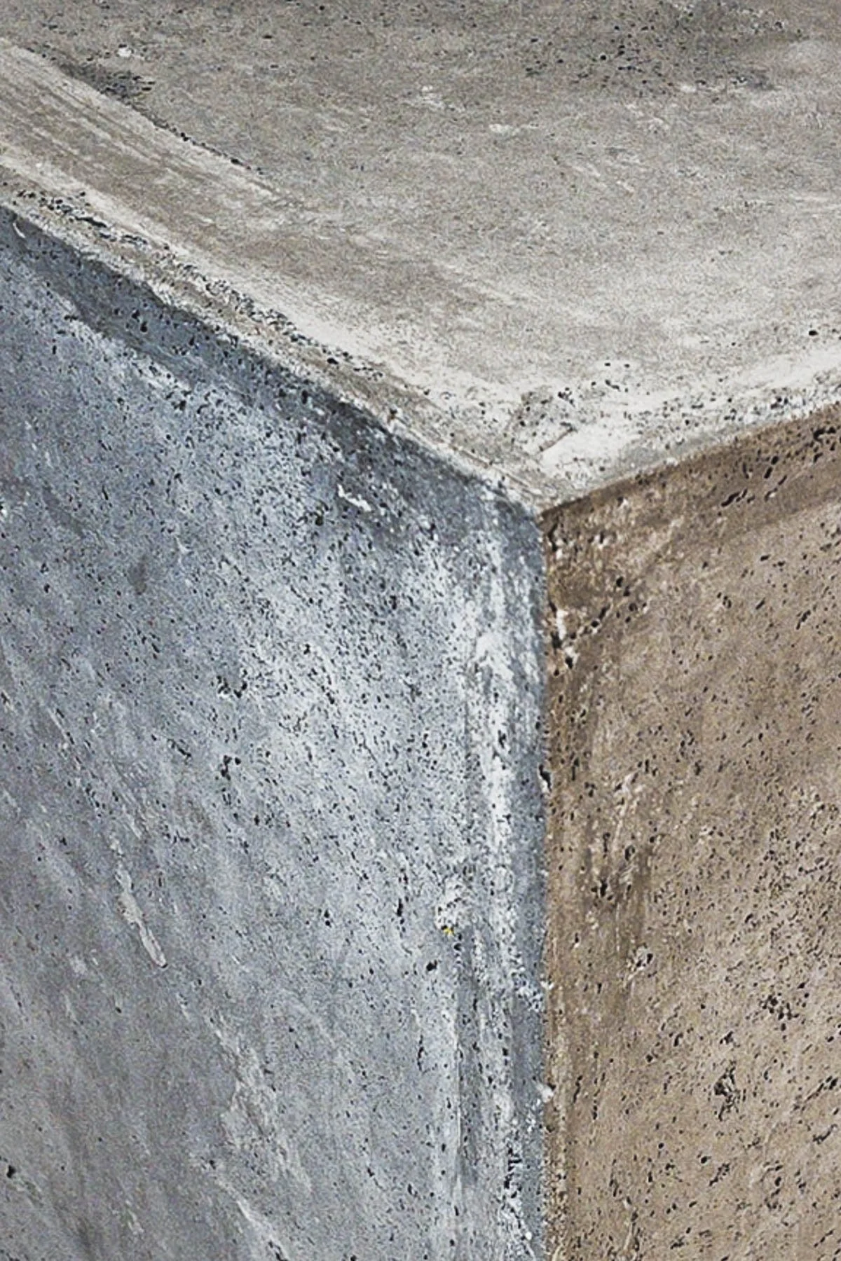 Sculptural concrete edge detail with exposed mineral texture, softened transitions, and natural tonal variation from The Concrete Anomaly furnishing collection.