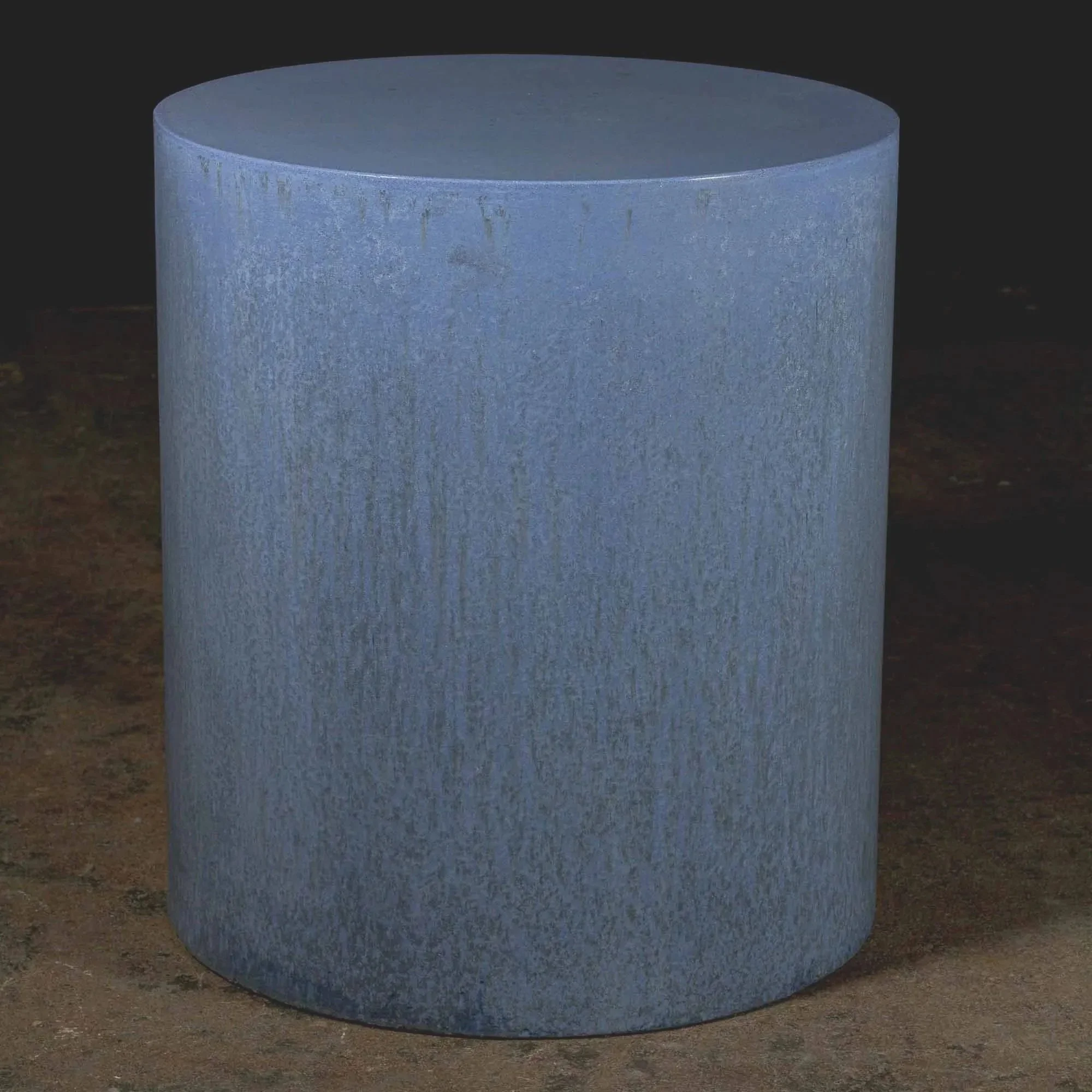 Minimal concrete pedestal side table featuring muted blue tones, atmospheric texture, and sculptural monolithic form.