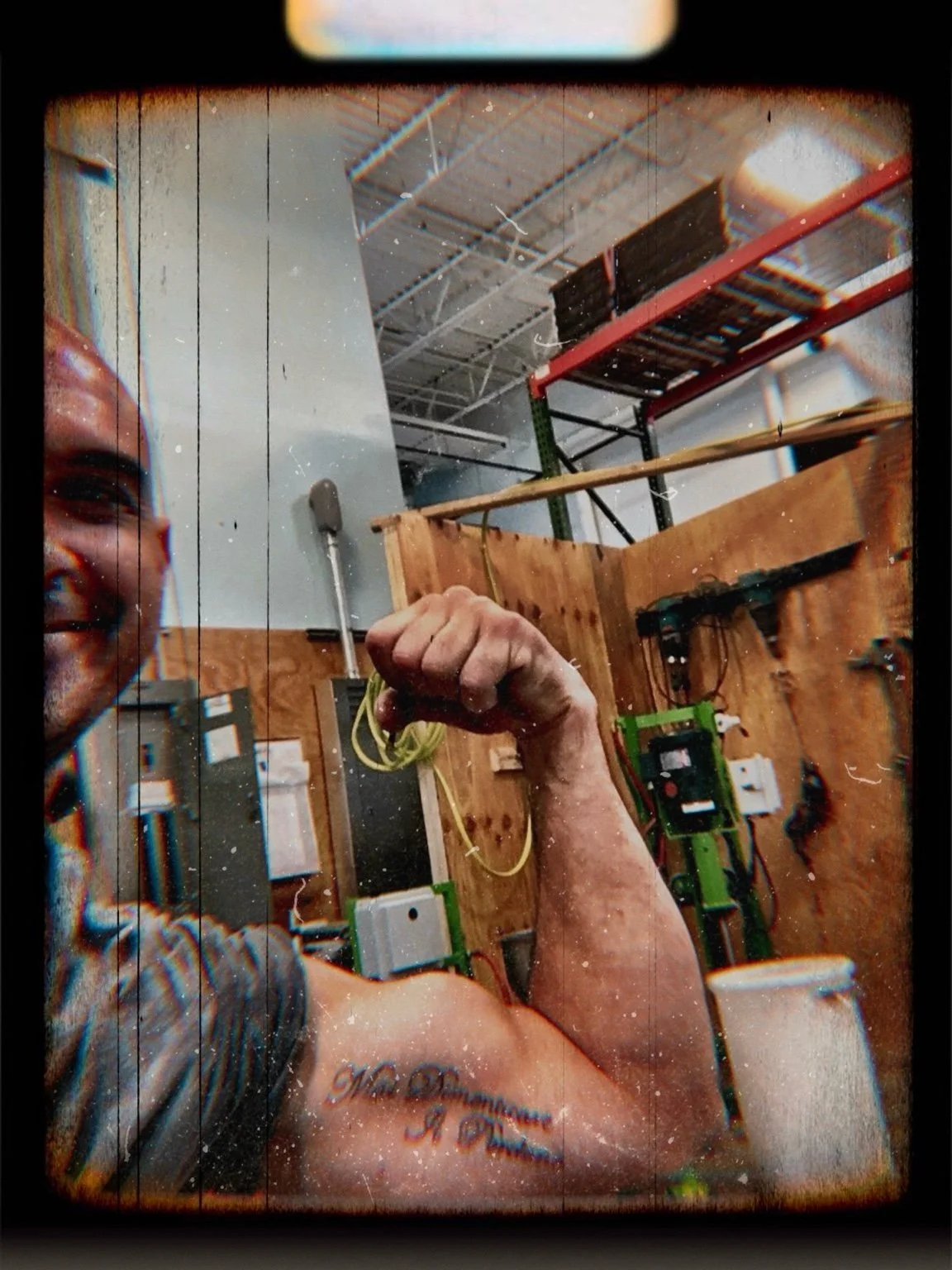 Portrait of the artist inside the studio, arm raised mid-workday, documenting the physical demands behind concrete fabrication.